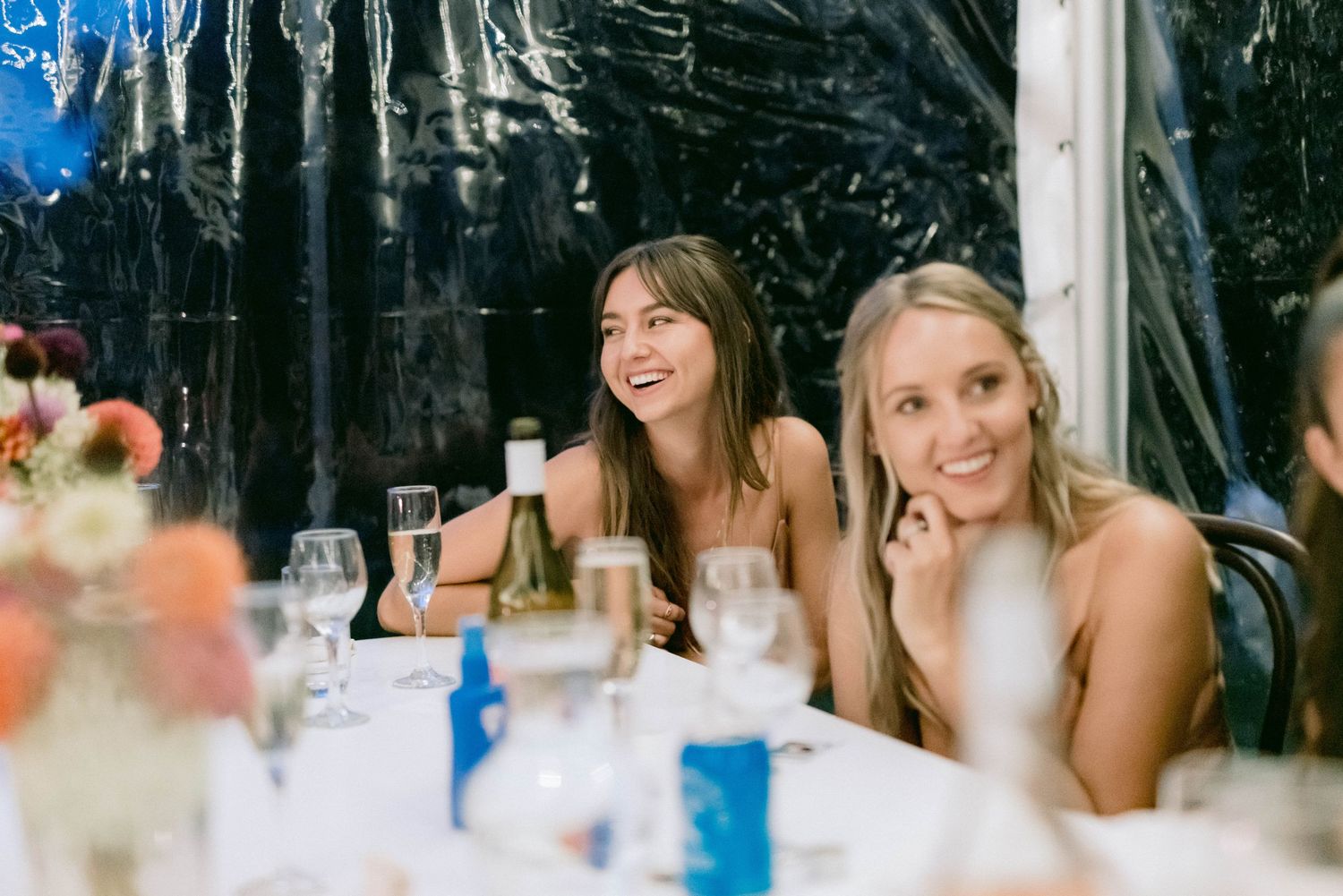 Guests enjoying drinks and conversation at an elegant outdoor tented reception.