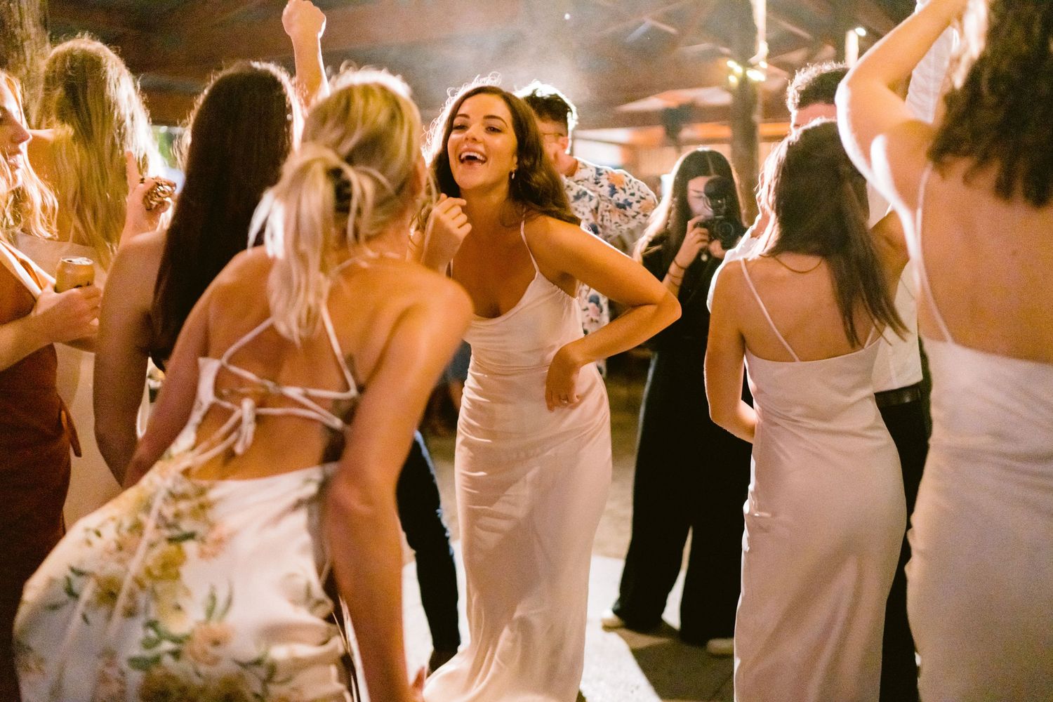 Wedding party members dancing and celebrating during the reception.