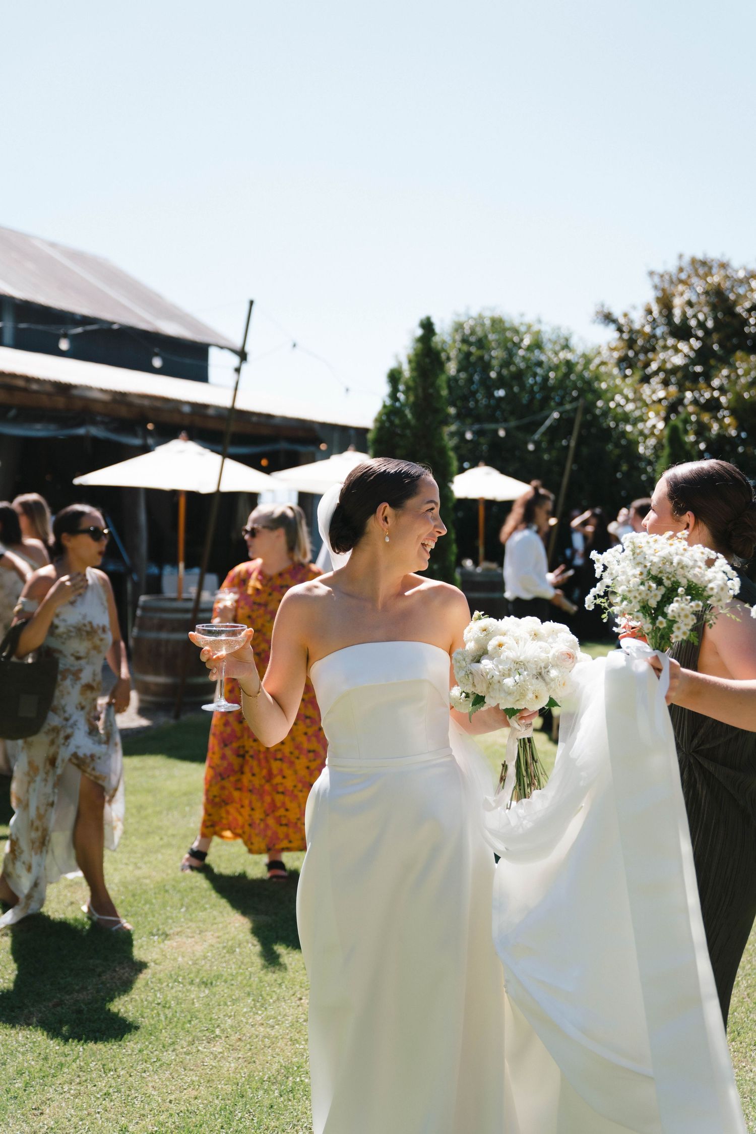 Wedding guests dancing and celebrating in a sunny outdoor garden party on a beautiful summer day.