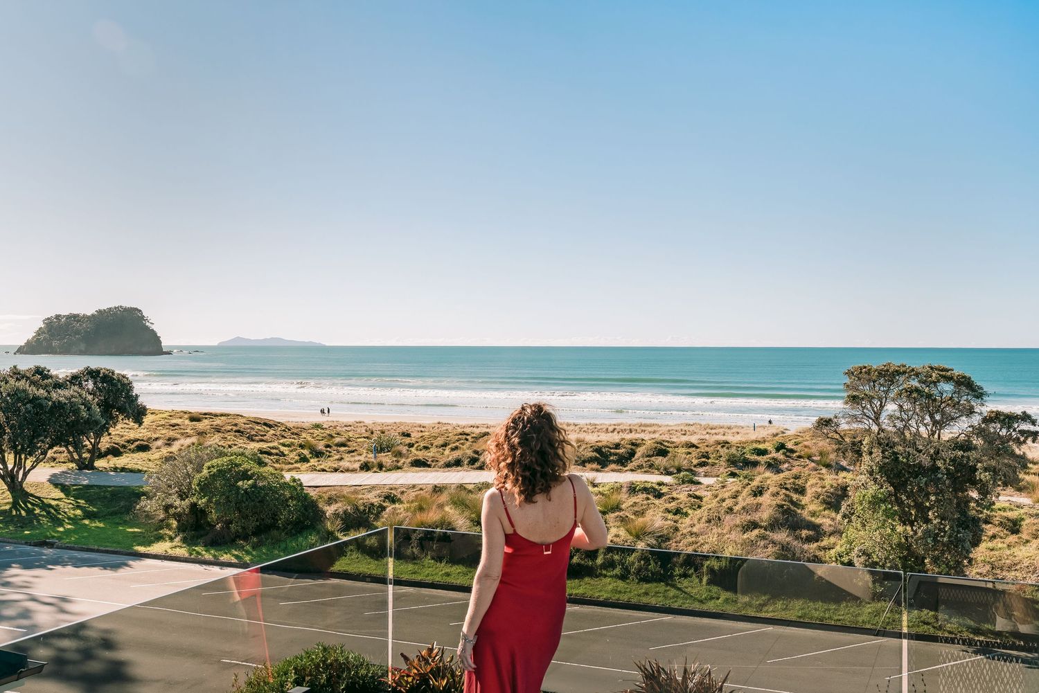 Panoramic coastal view of a beach landscape with sand dunes and ocean horizon.