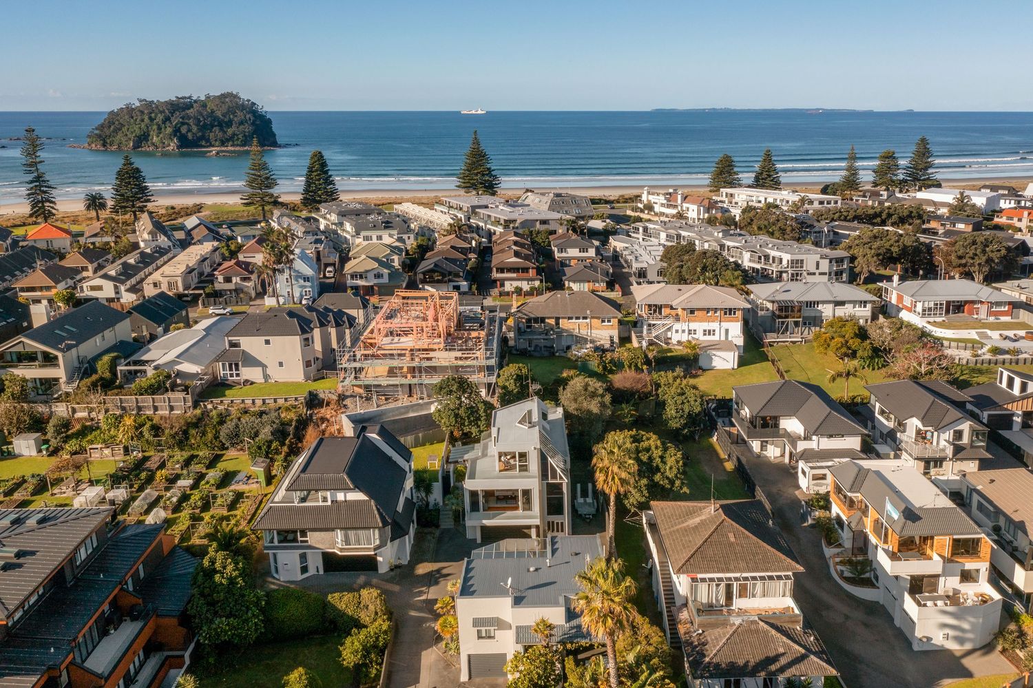 Aerial panorama of oceanfront neighborhood with luxury homes and pristine beaches.