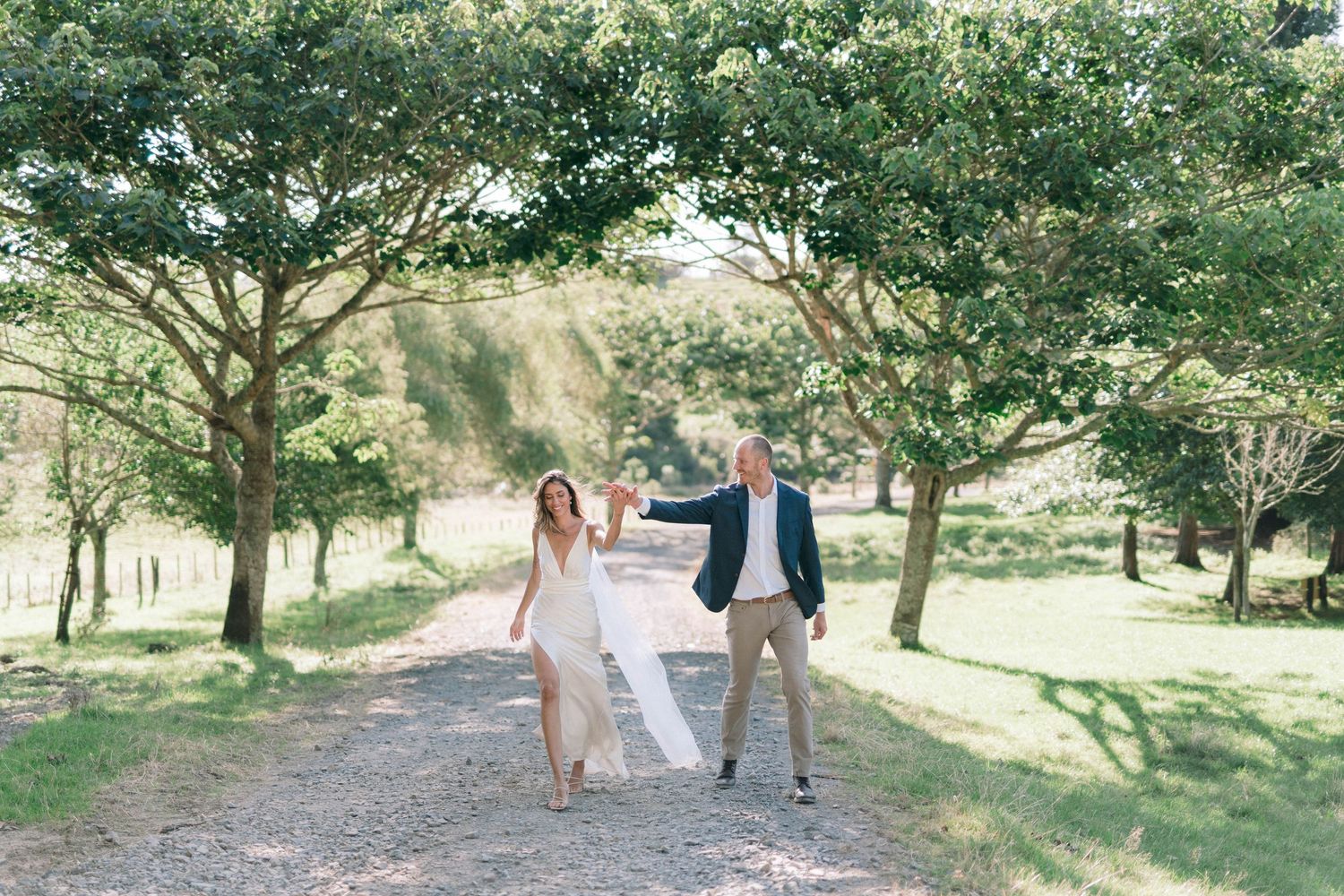 Wedding party walking through a scenic outdoor garden setting.