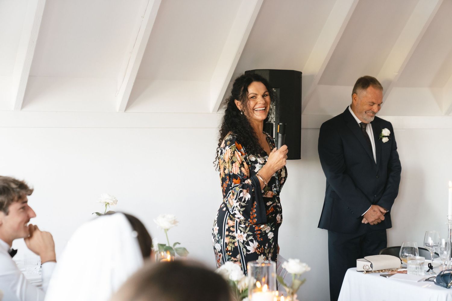 Wedding reception scene in modern white interior with vaulted ceilings.