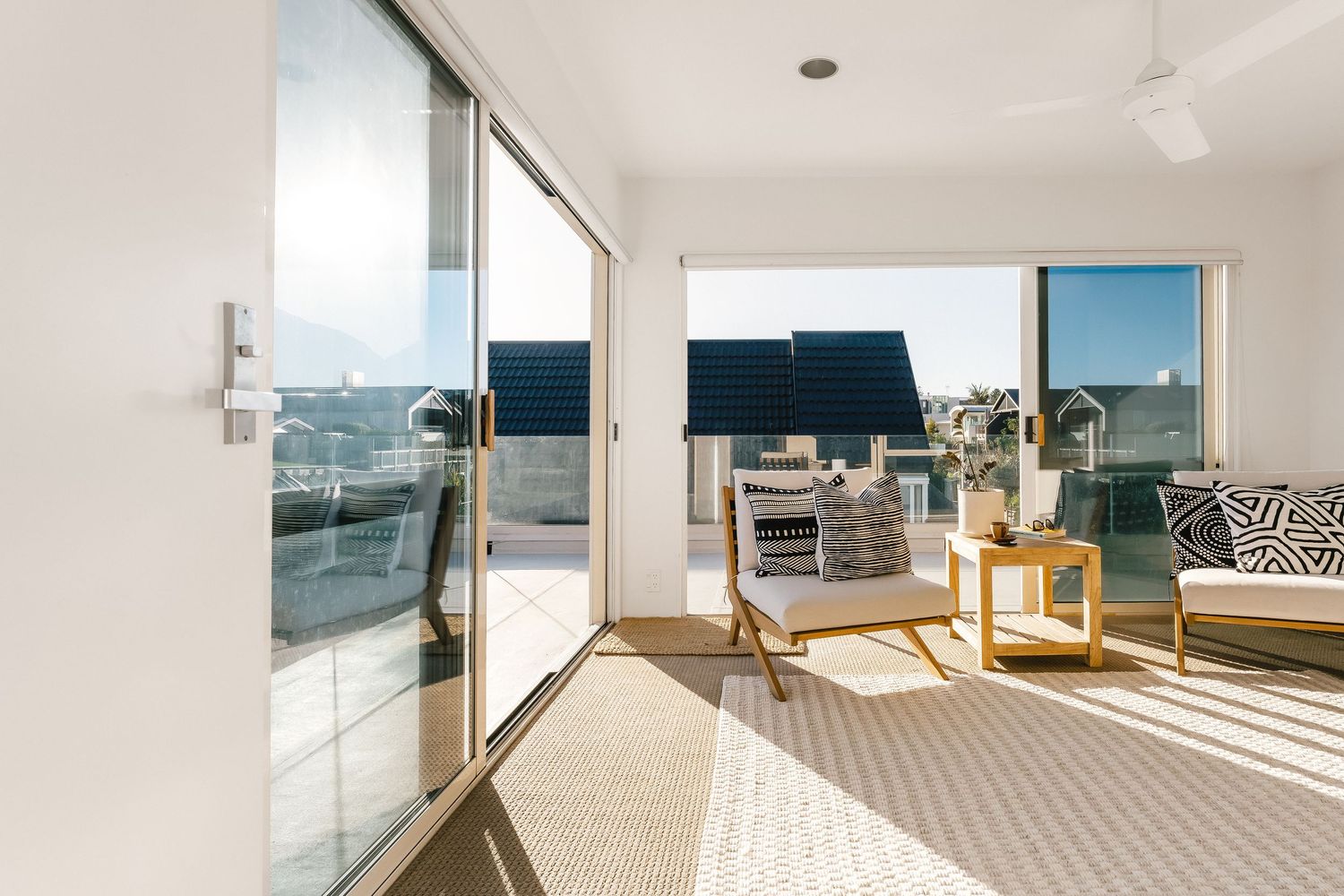 Elegant open-plan living space with ocean views through large windows and contemporary furnishings.