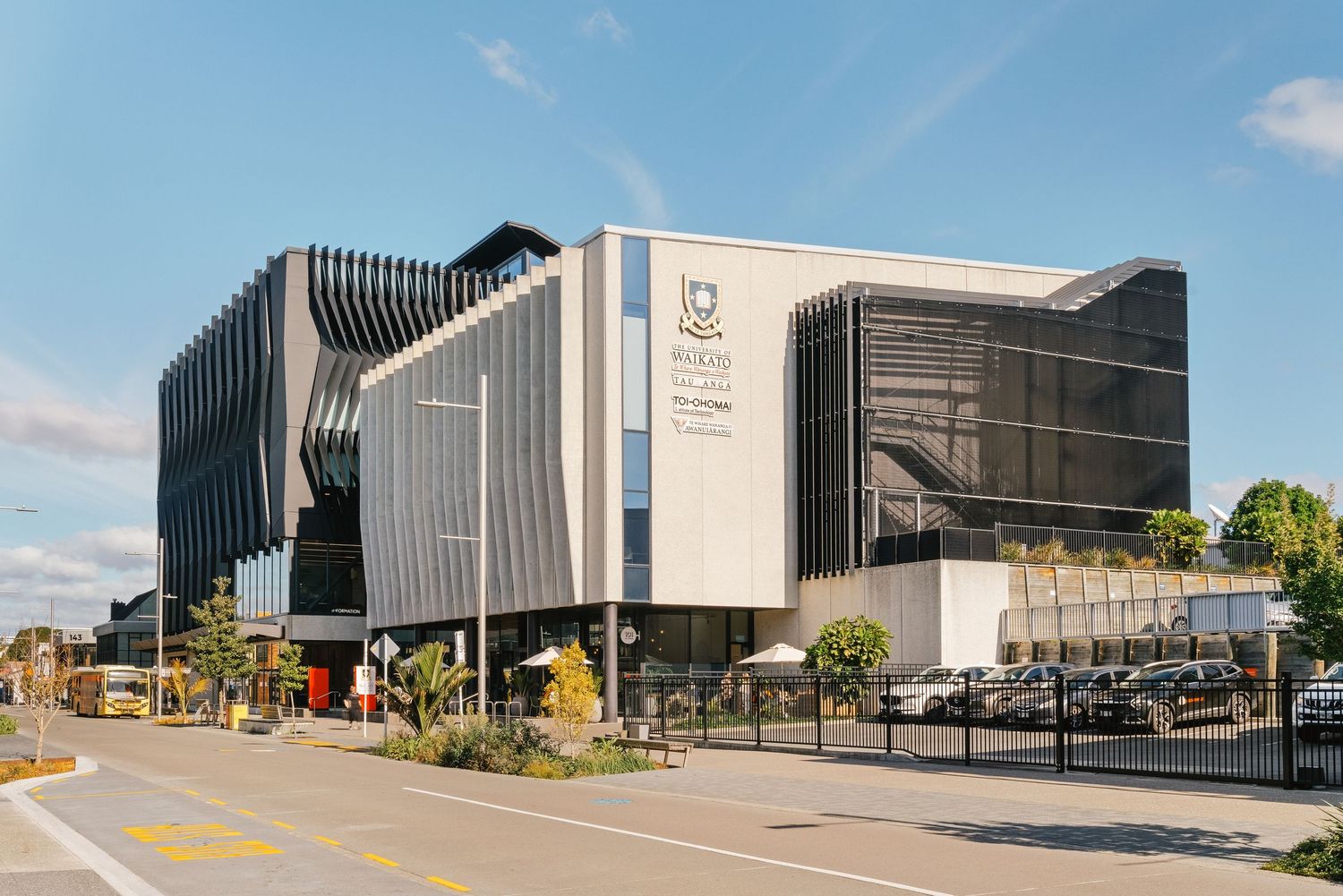Modern architectural building with angular black and white exterior design featuring geometric patterns and glass windows.