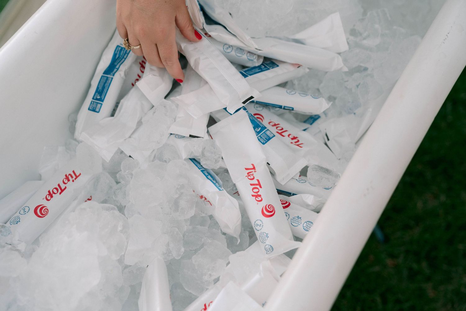 Cooler filled with ice and drinks at an outdoor event.