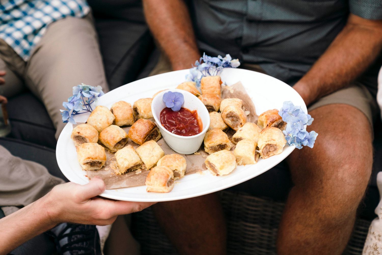 Platter of appetizers with dipping sauce being served at a casual party.