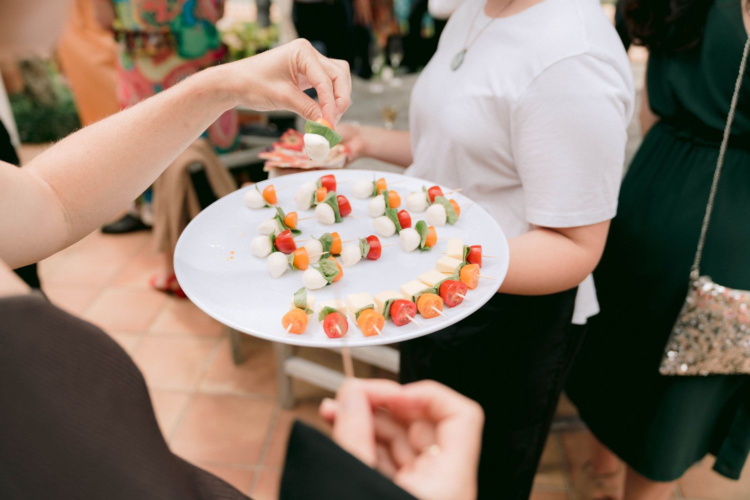 Elegant appetizers being served on white plates at a wedding reception.