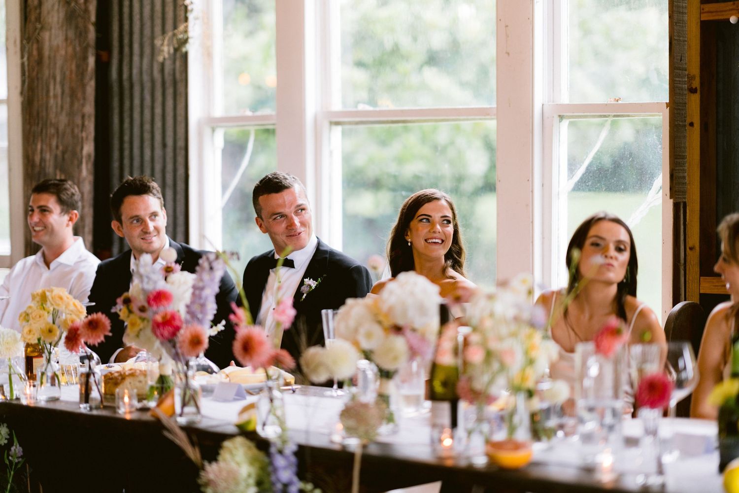 Wedding guests seated at long tables during an elegant indoor reception.