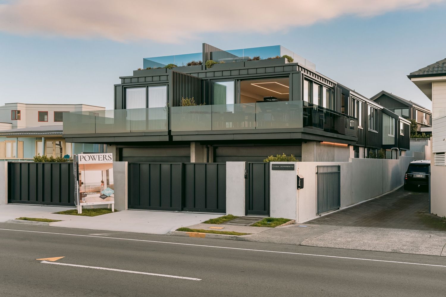 Contemporary two-story house with black and white exterior featuring a rooftop terrace.