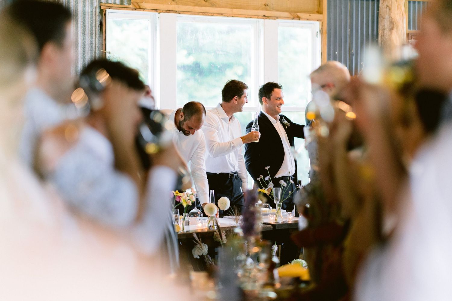 Wedding guests celebrate and raise their glasses during a reception toast.