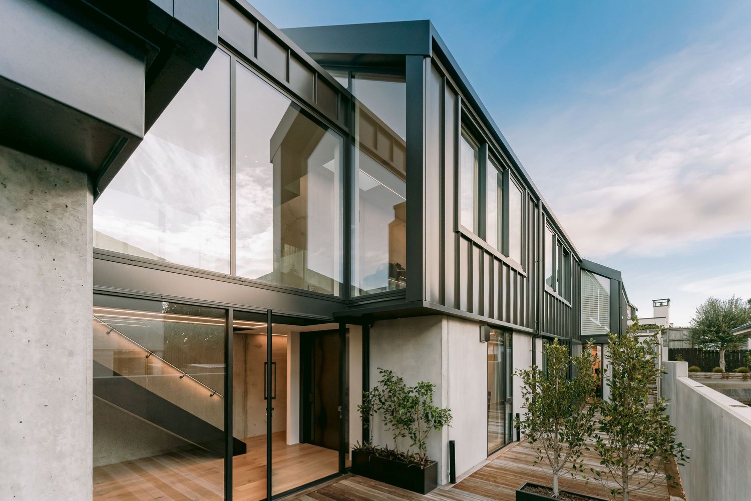 Modern architectural design featuring glass panels and clean lines on a contemporary multi-level home exterior.