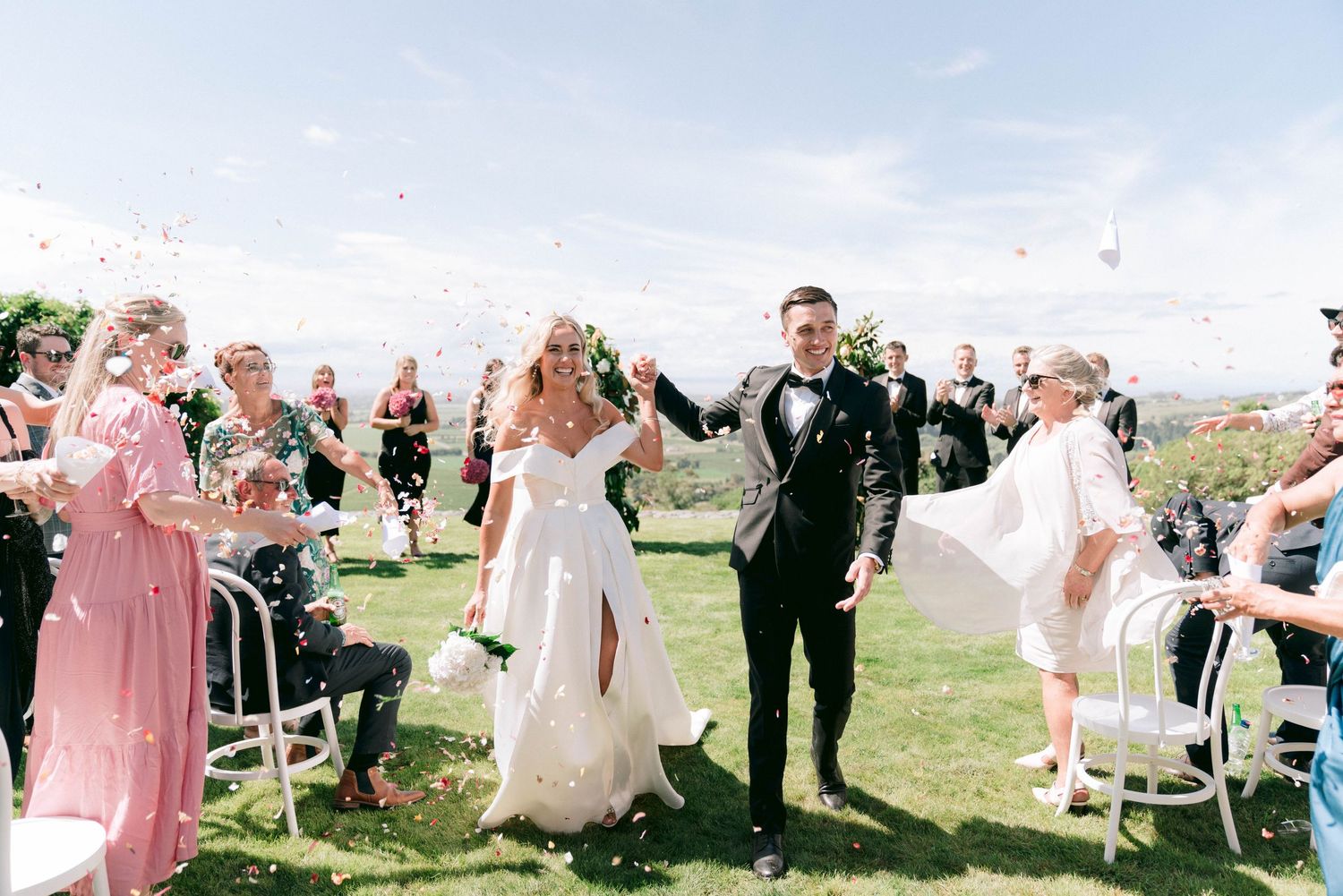 Wedding guests celebrating during an outdoor ceremony with mountain scenery.