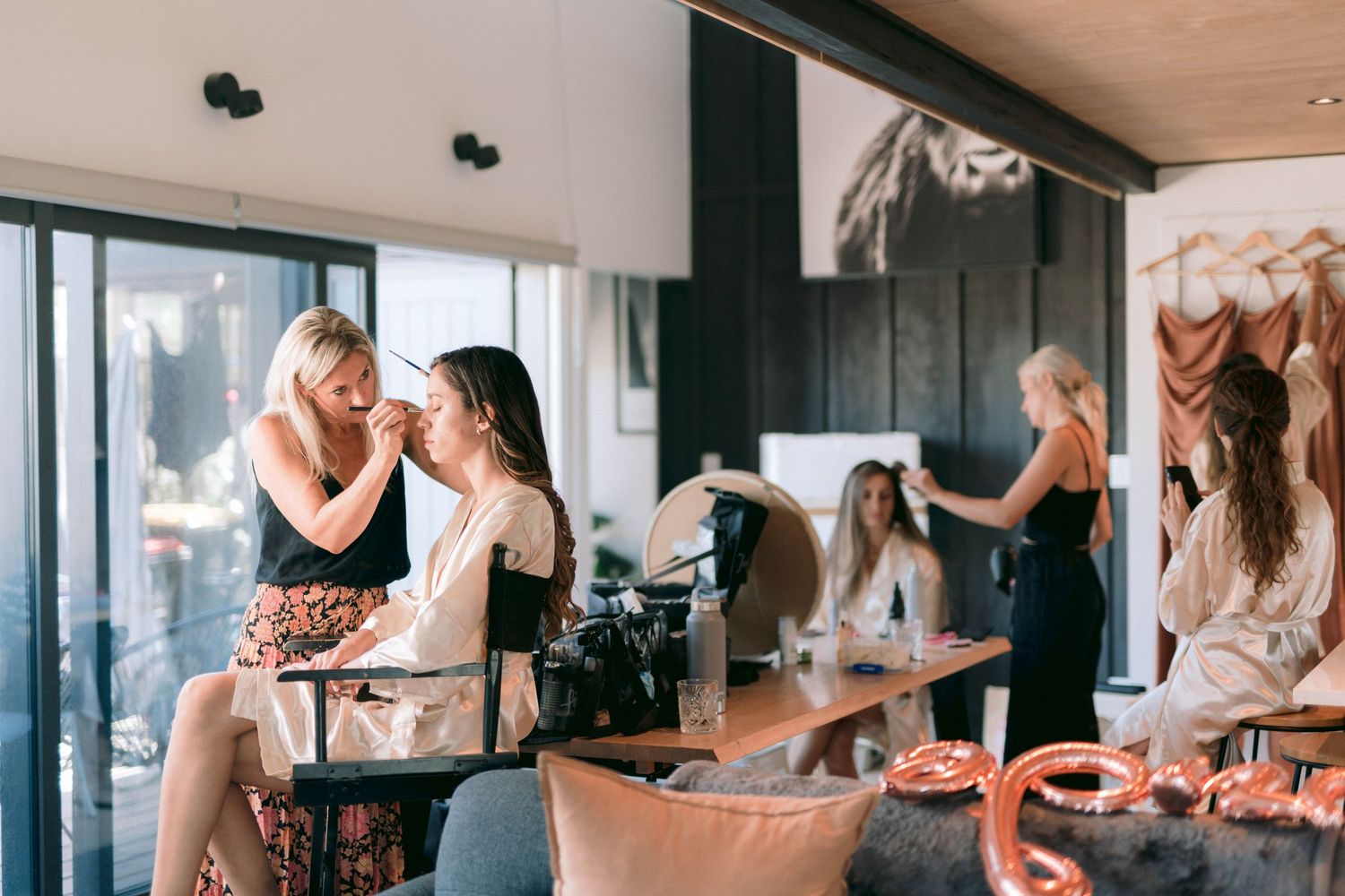 Coffee shop customers cozy up at a wooden counter while baristas prepare hot beverages in a modern cafe setting.