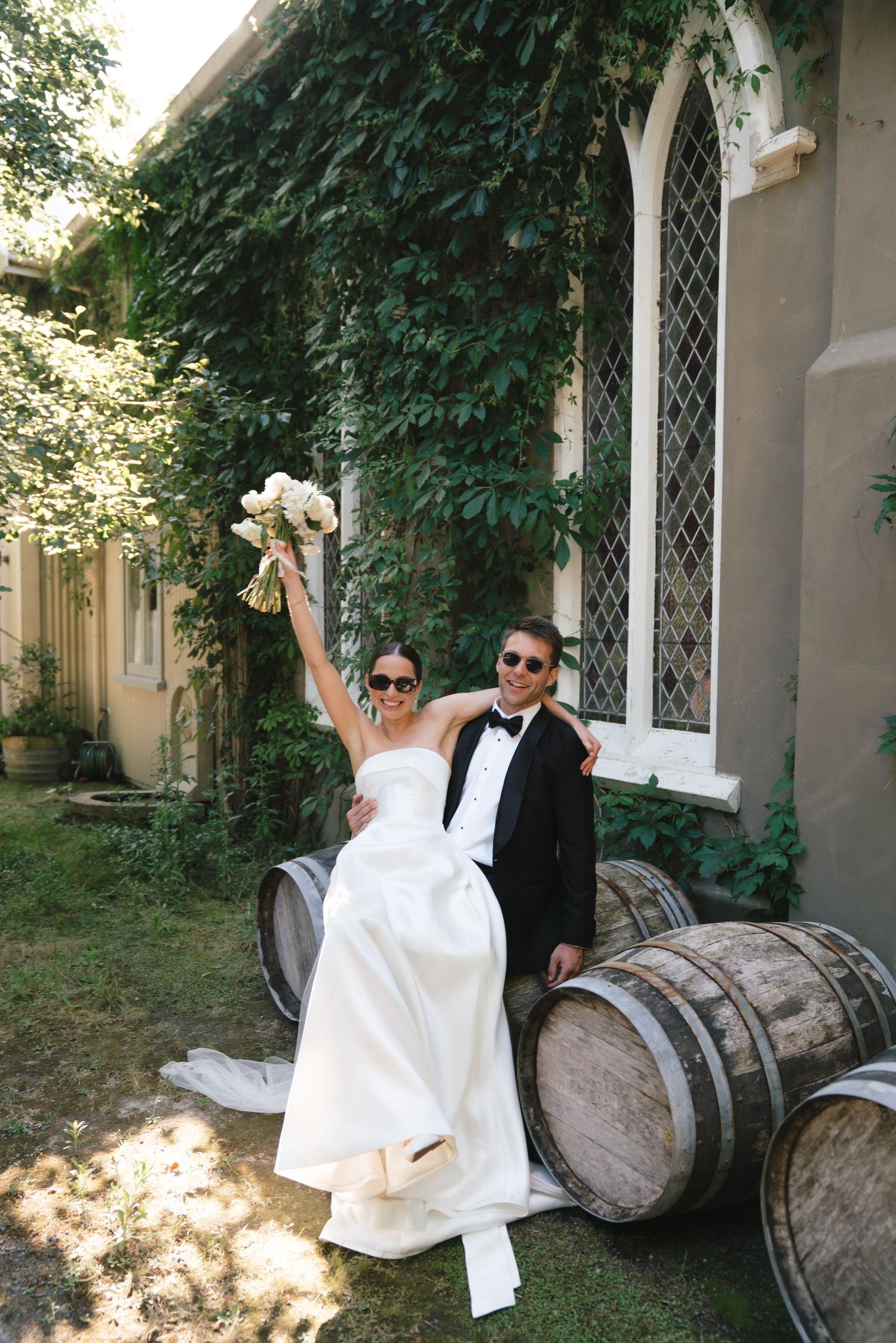 A celebratory moment on wooden barrels outside an ivy-covered building.