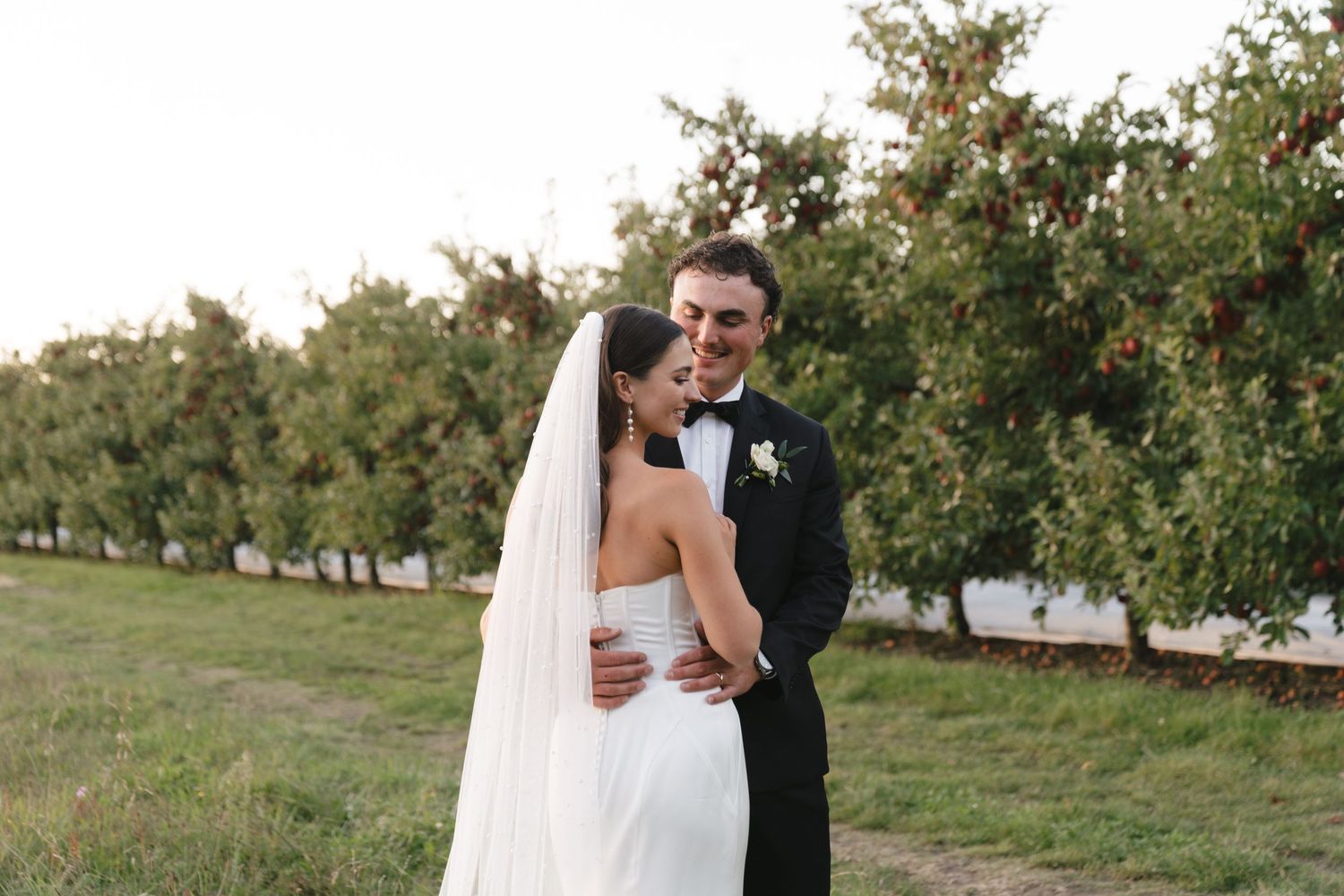 Outdoor wedding portrait session in an orchard setting.