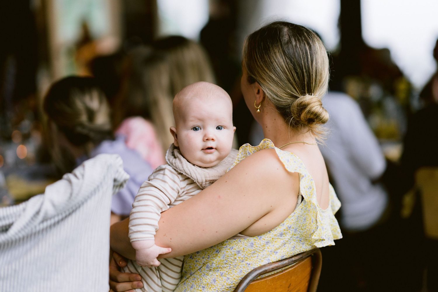 Small child in formal attire plays during a wedding celebration.