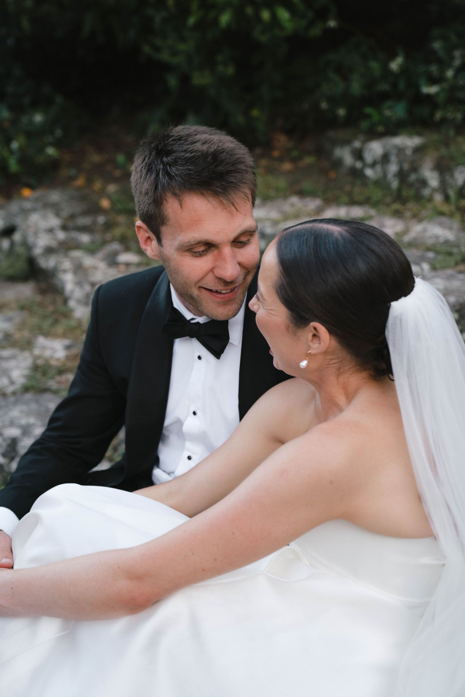 Intimate moment between newlyweds as they share loving glances in outdoor setting.