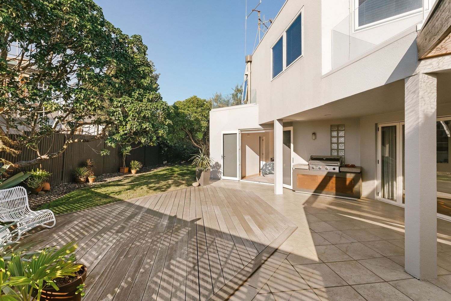 Contemporary white house with multi-level outdoor decking and clean architectural lines.