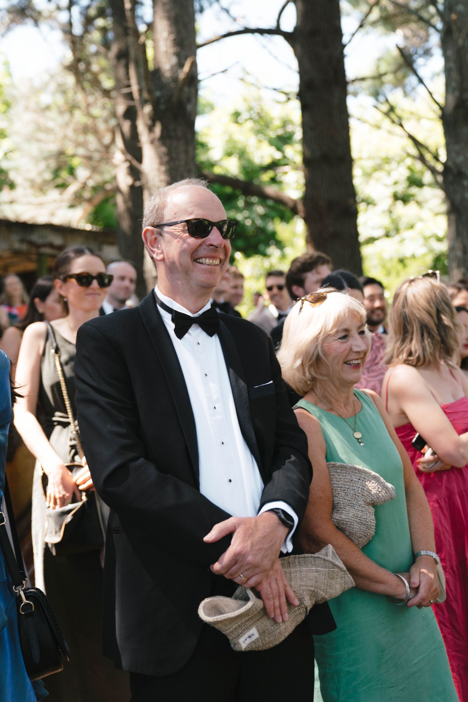 Wedding guests dressed in formal attire enjoying an outdoor celebration.