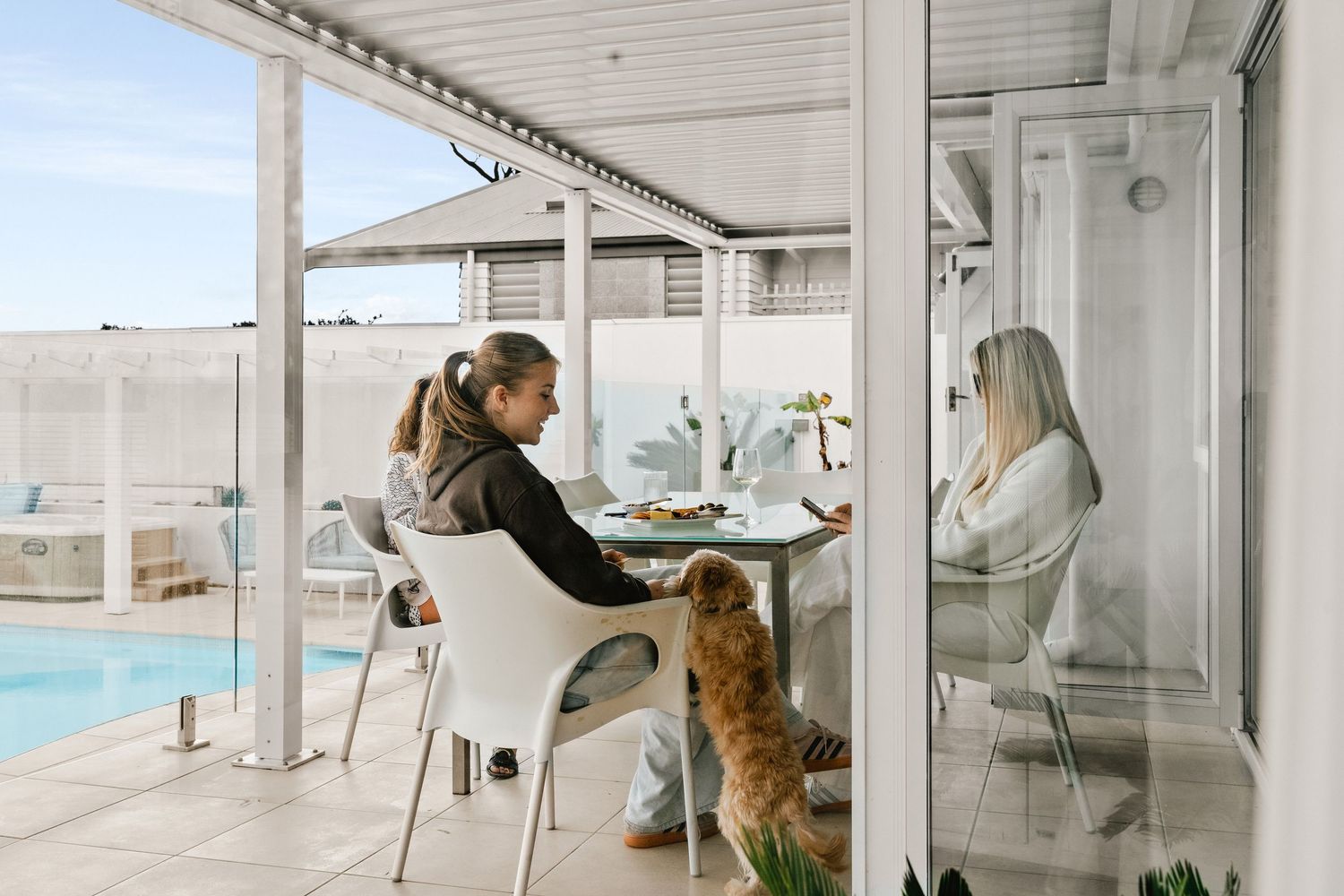 Modern coastal home interior with white walls and large windows overlooking the ocean.