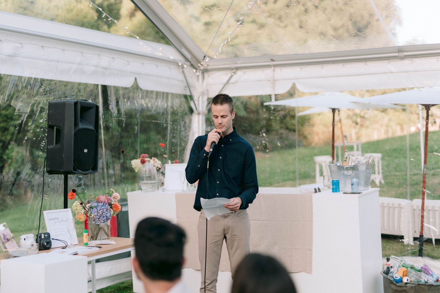 White tent setup in an outdoor venue with mountains visible in the background.