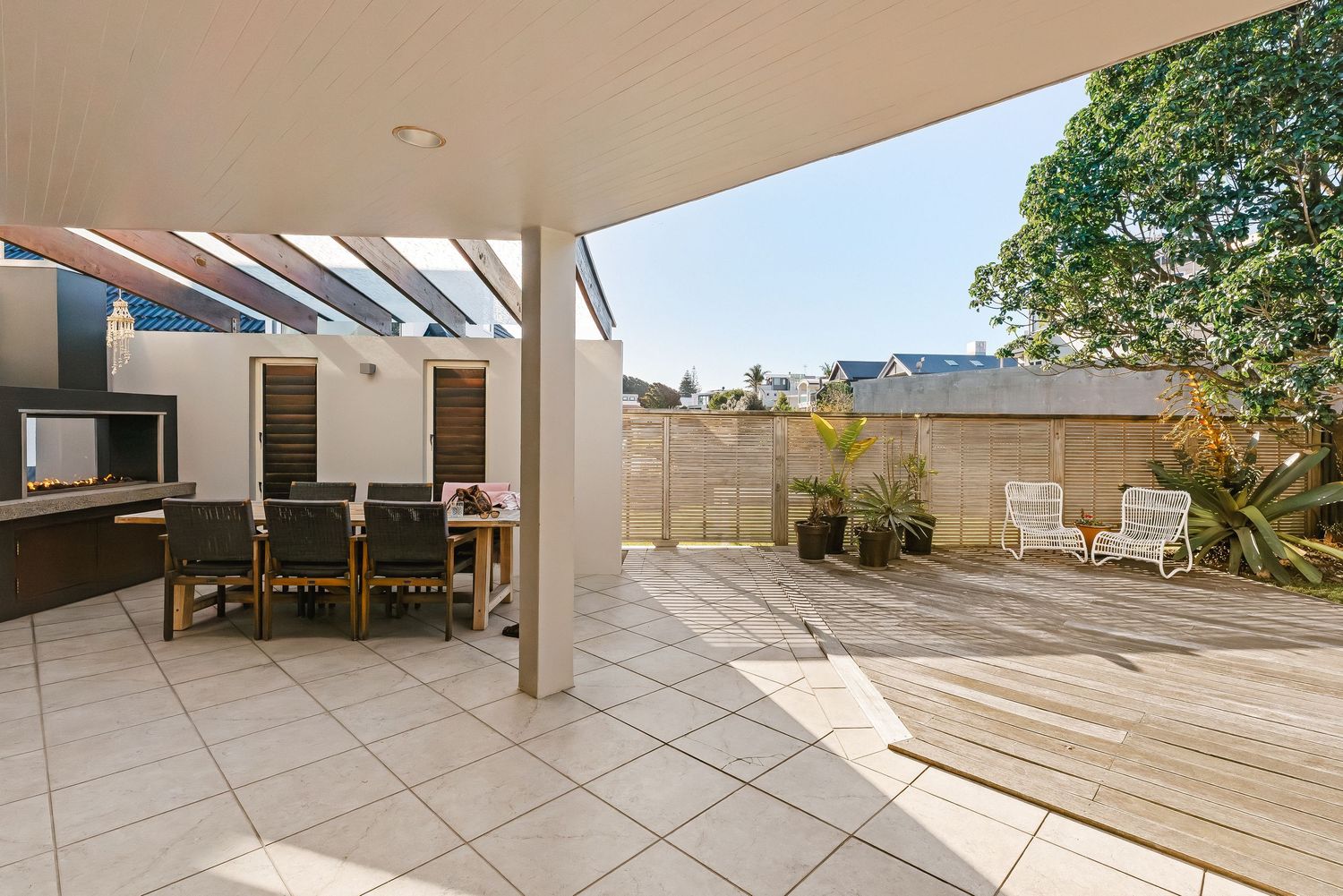 Wide angle view of a modern minimalist balcony with white walls and tiled flooring extending into the distance.
