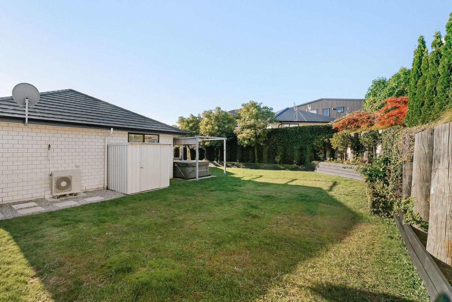 Spacious backyard with well-maintained green lawn and mature trees along the perimeter.