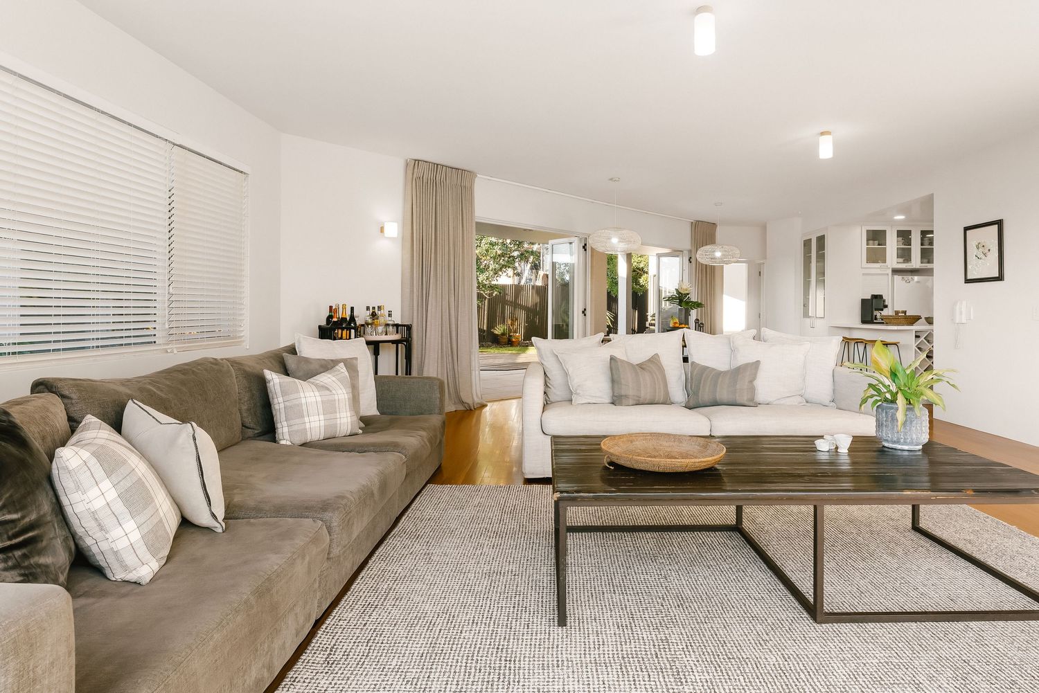 Modern living room featuring neutral tones, plush seating, and recessed lighting.