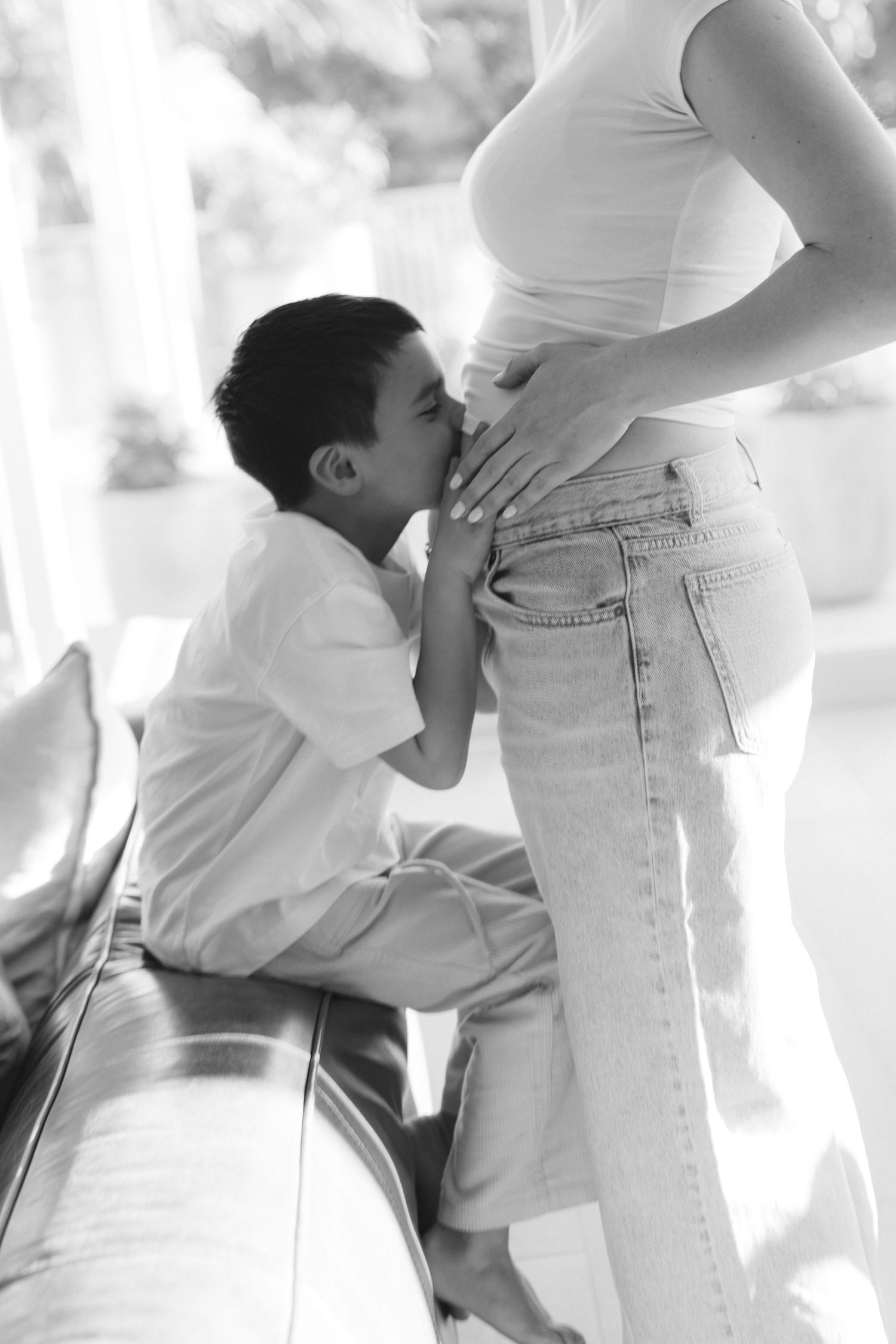 A series of intimate black and white maternity photos showing tender moments between expectant parents.