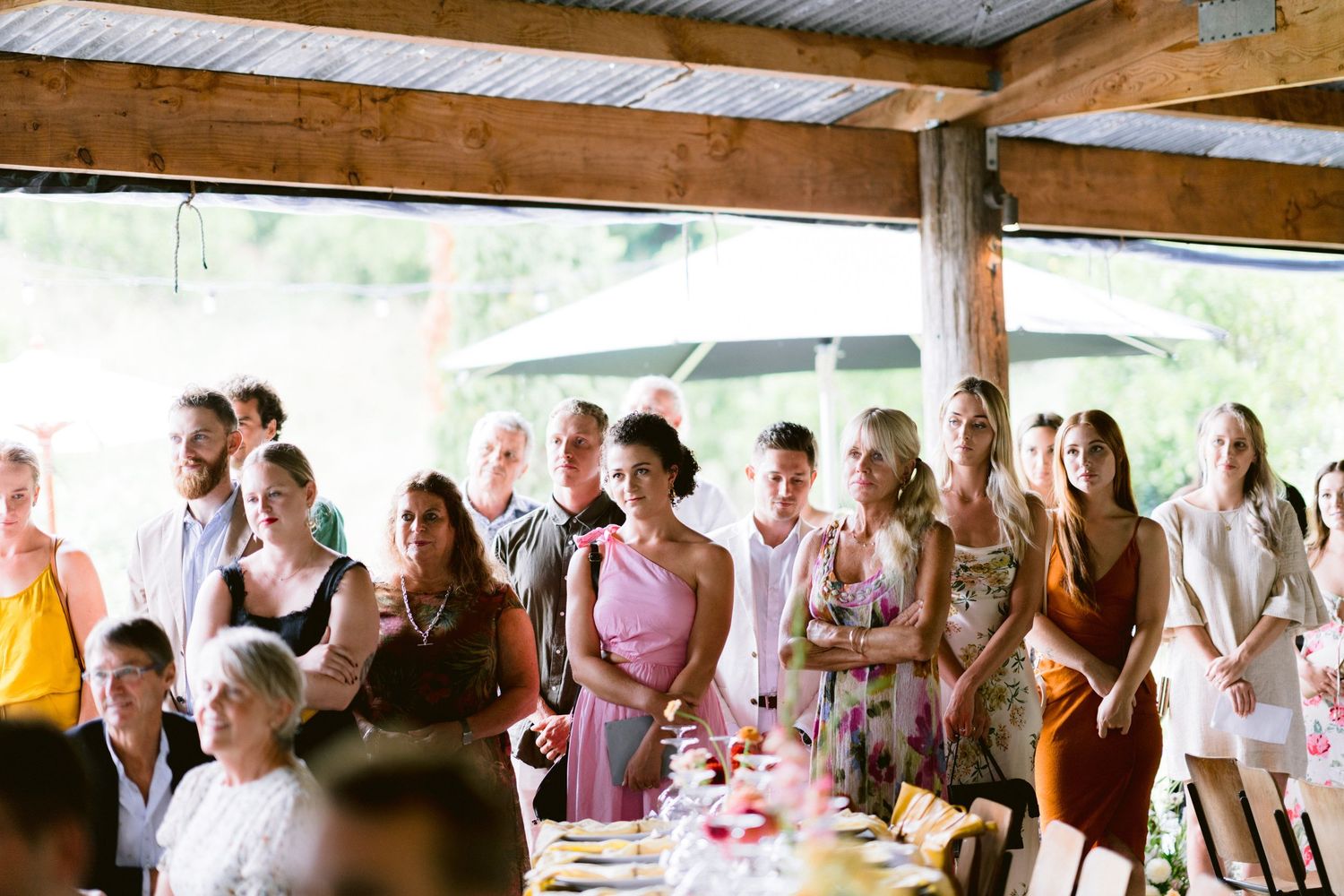 Wedding reception guests mingling and celebrating under a covered outdoor venue.
