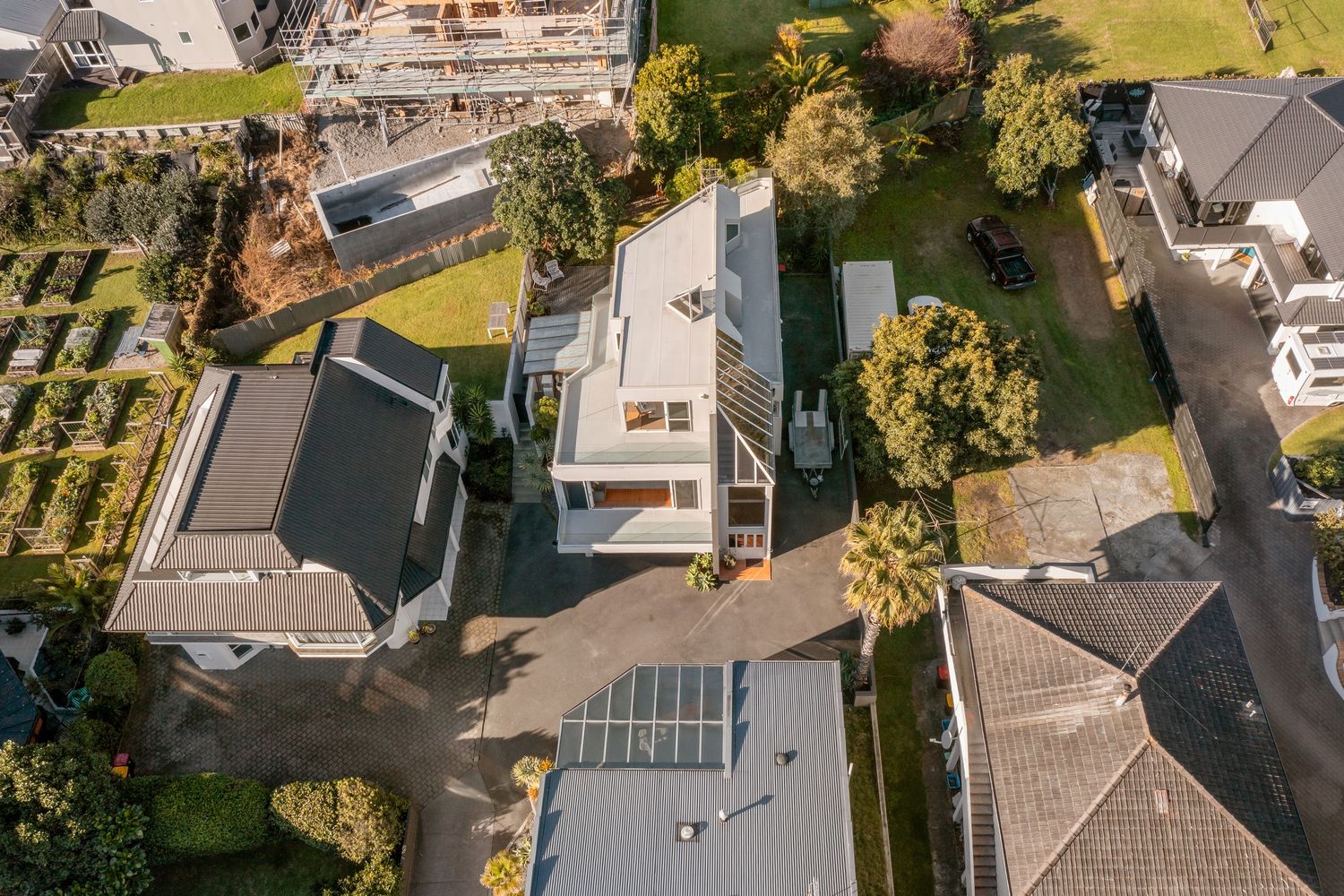 Bird's eye view of residential neighborhood showing rooftops, yards and streets in a beachside community.