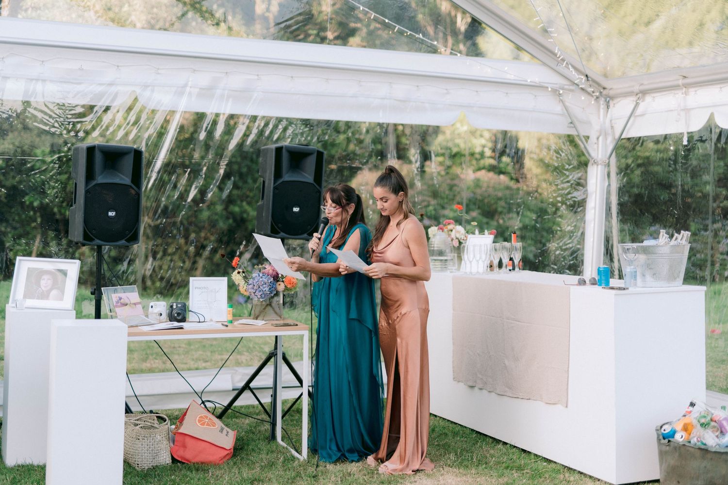 White tent setup with tables and decorations for outdoor gathering.