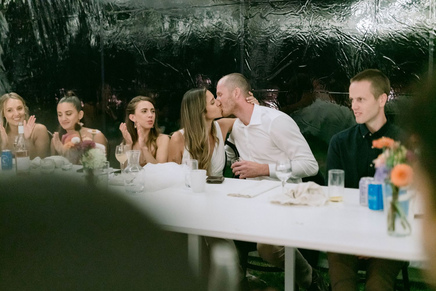 Wedding reception candid moments captured as guests dine at outdoor tables.