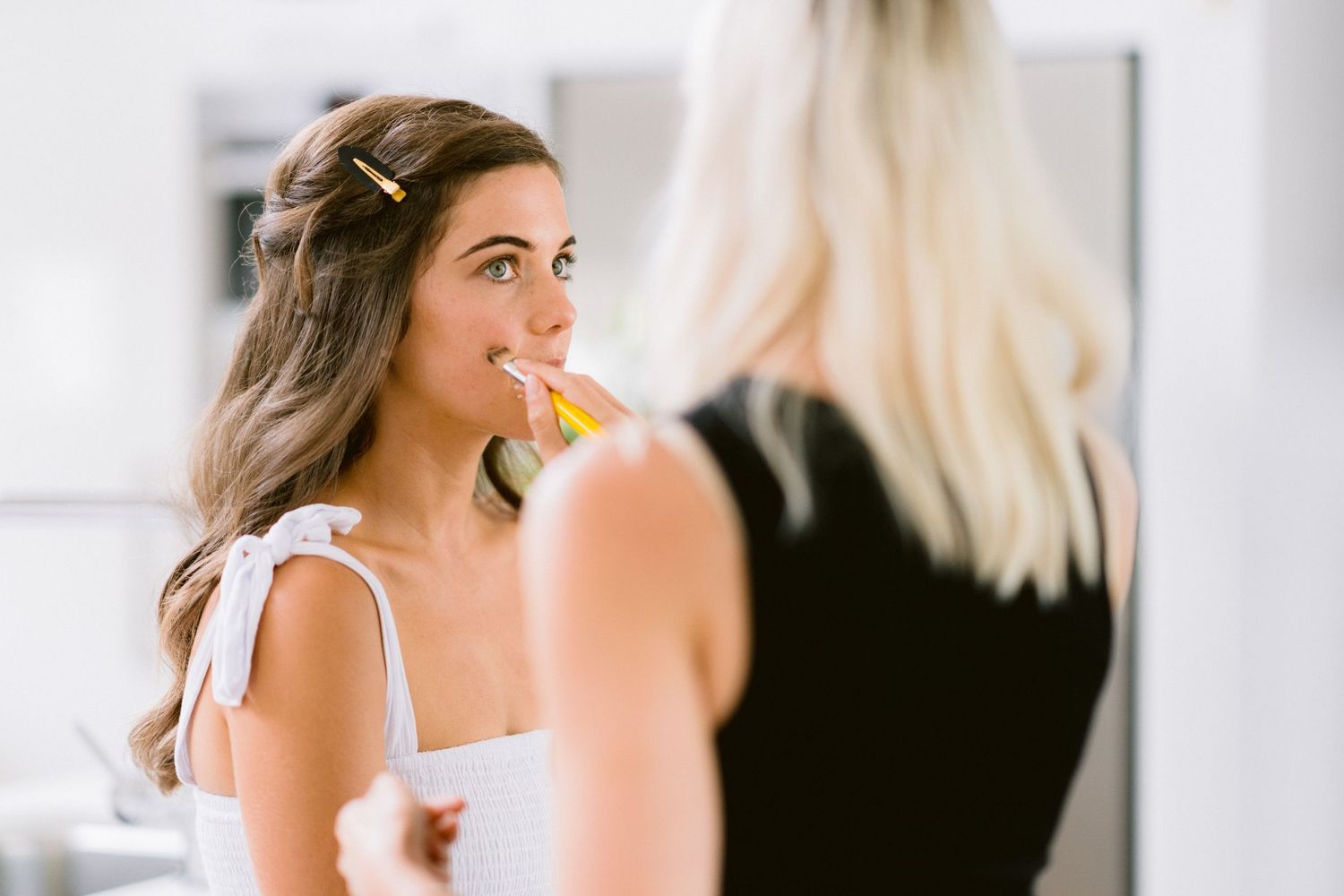 A series of candid wedding day photos showing laughter and joyful moments between elegant party members.