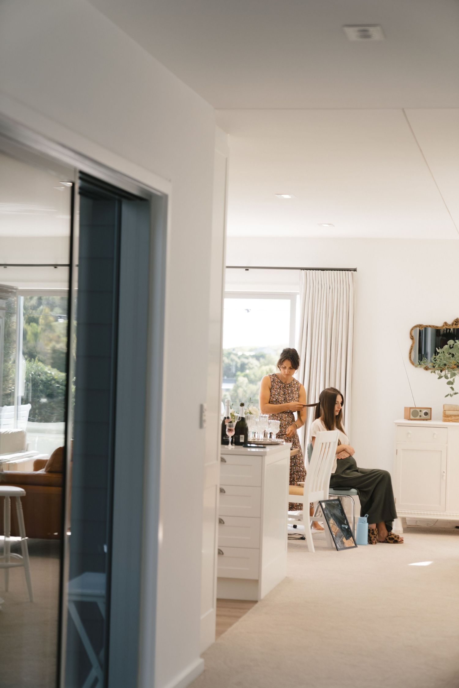 Interior of modern home with bright sunlit room and white furniture.