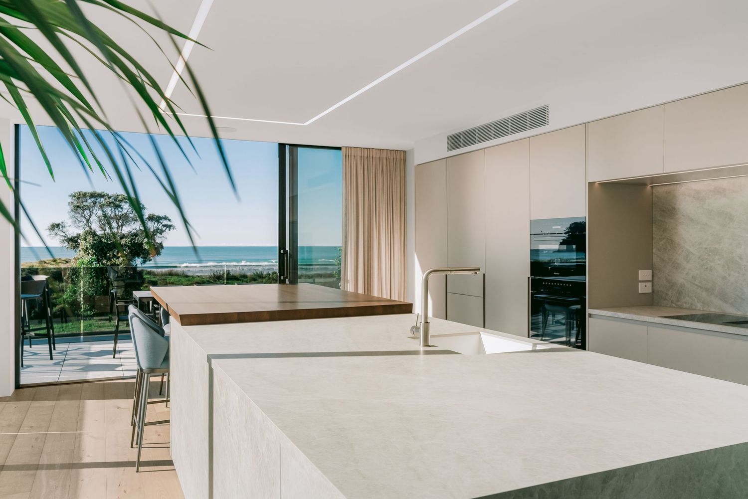 Bright modern interior with white walls and large windows offering stunning ocean views.