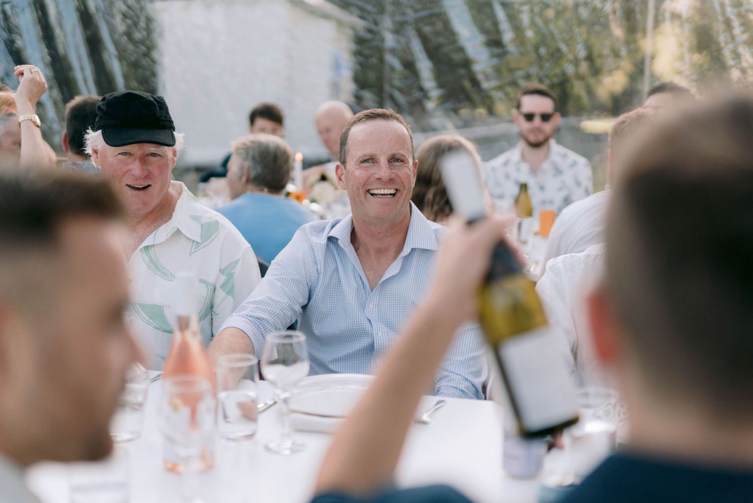 Wedding guests dining and celebrating at an outdoor reception.