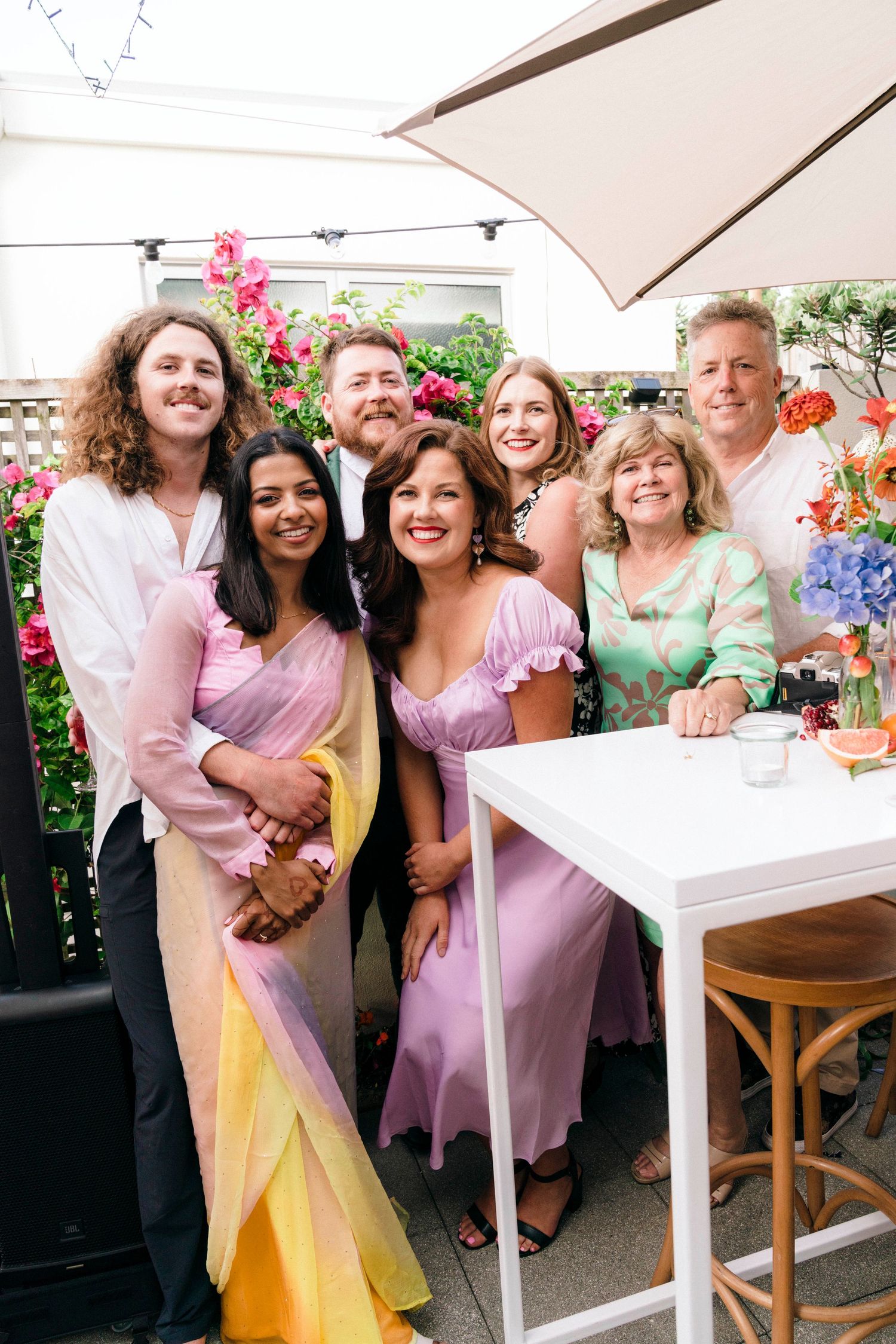 Festive outdoor garden party with guests in pastel and bright colored formal attire.