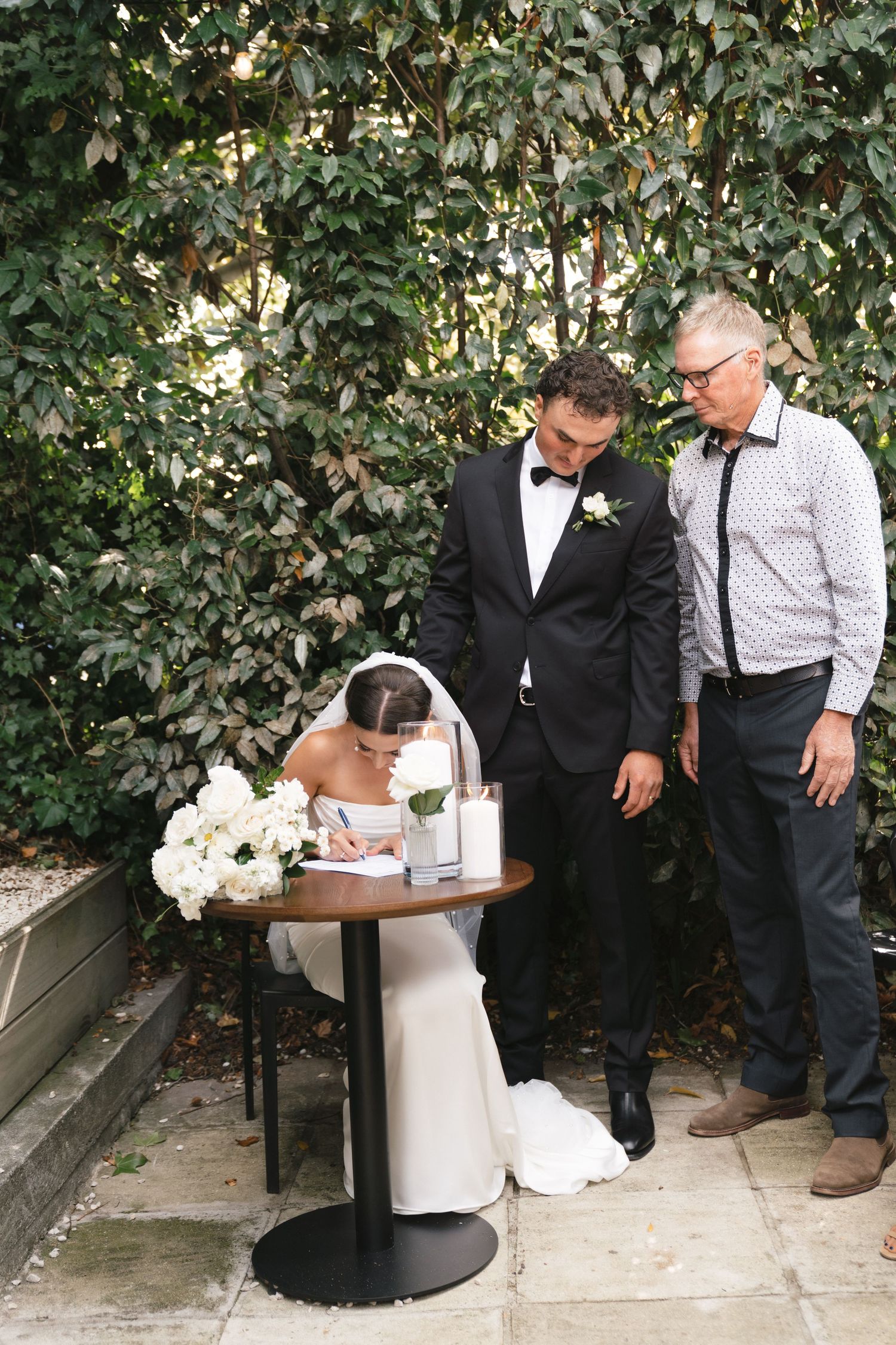 Sequence of wedding photos showing preparation and document signing in a garden setting with white floral decorations.