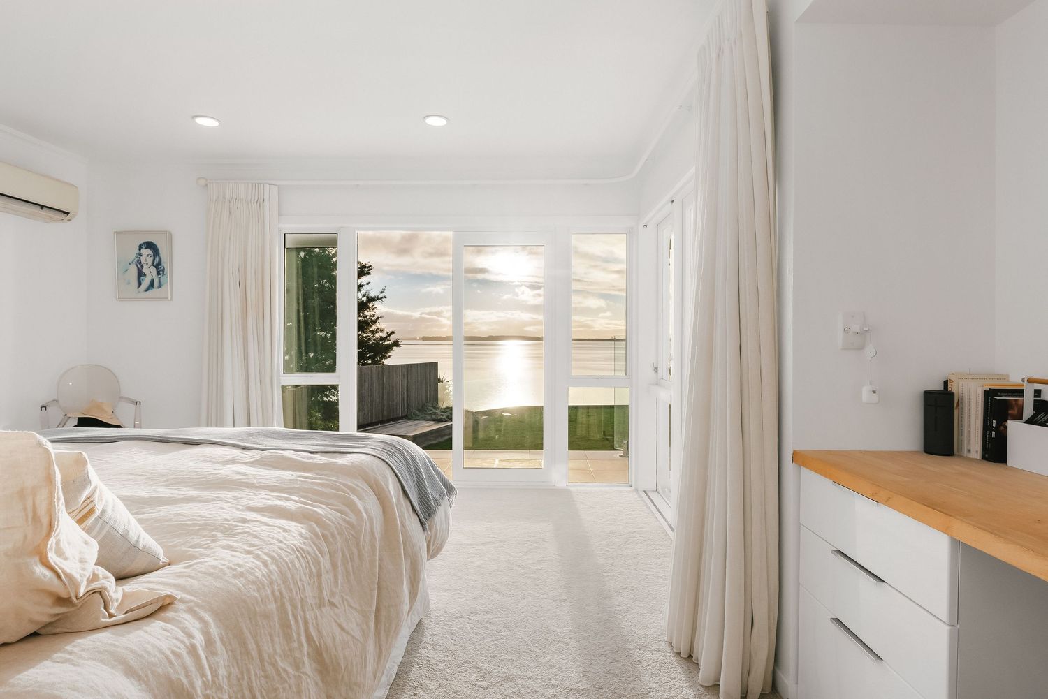 Bright open concept living space with white walls and natural light streaming through windows.