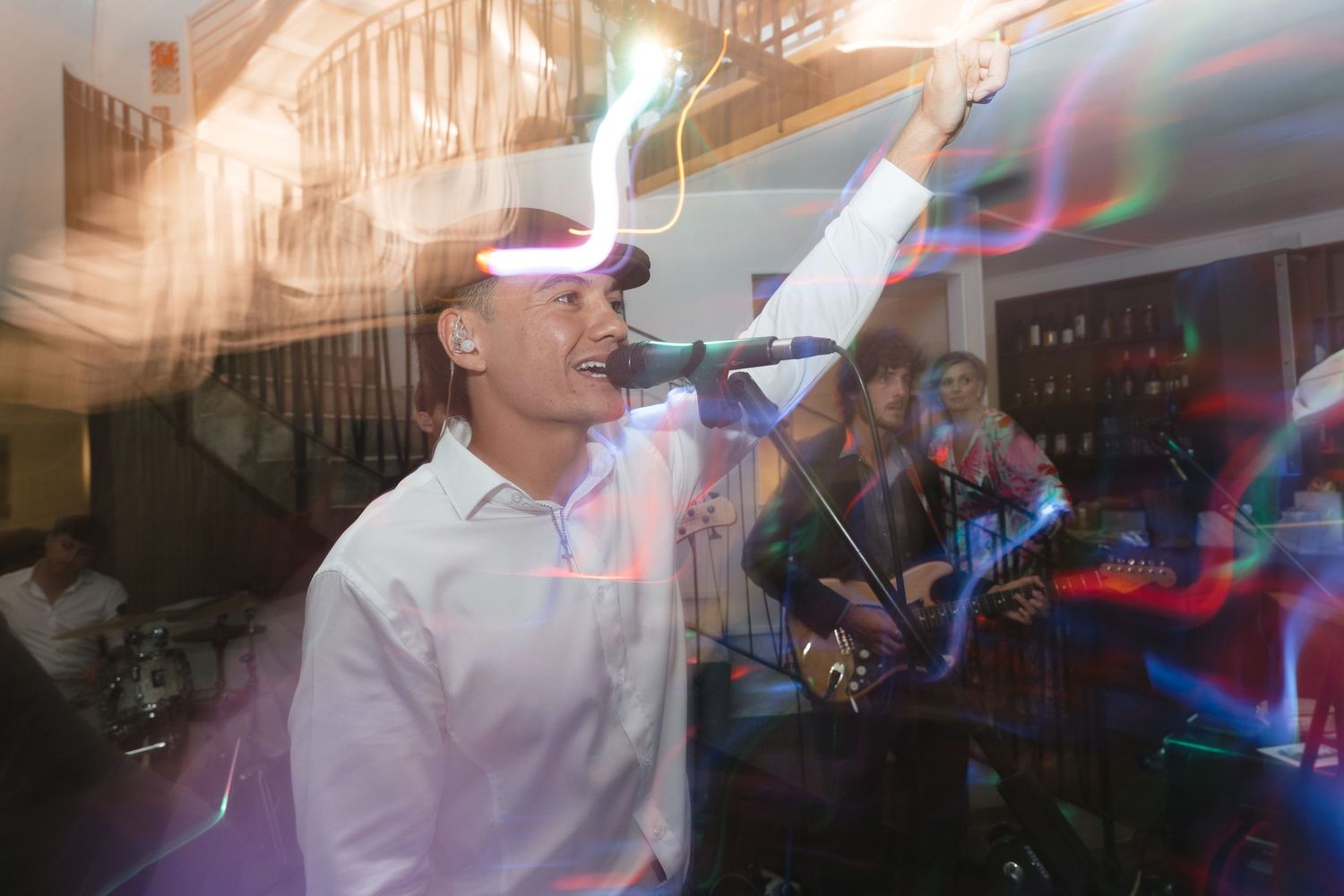 Dynamic nighttime wedding reception with colorful lighting and dancing guests.