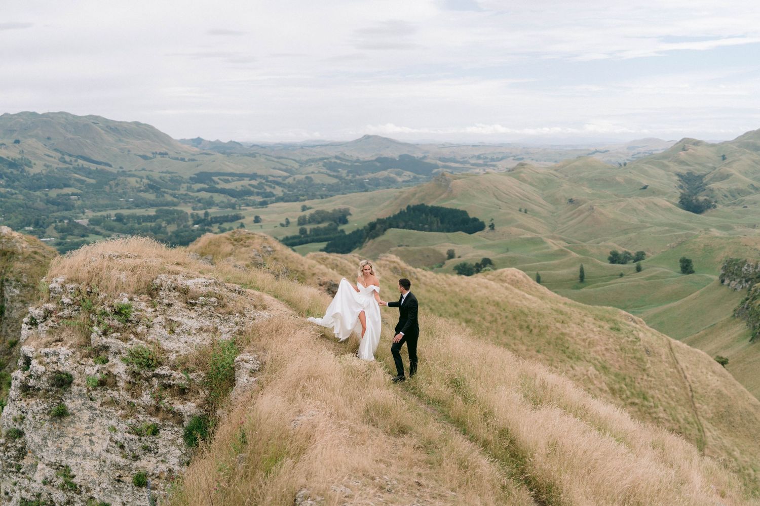 Scenic mountain ridge overlooking vast green valleys and countryside.