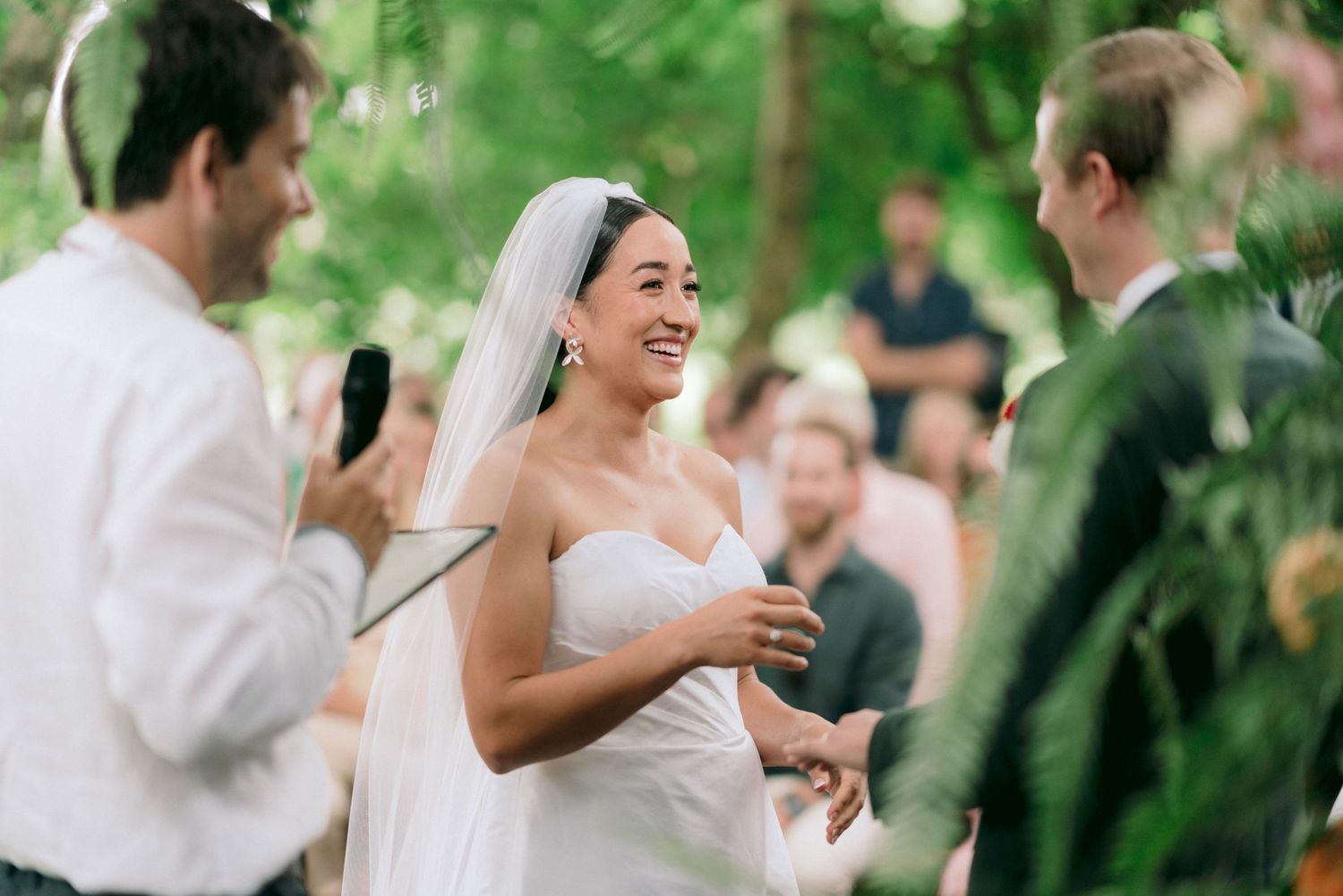 A joyful wedding celebration moment under green foliage.