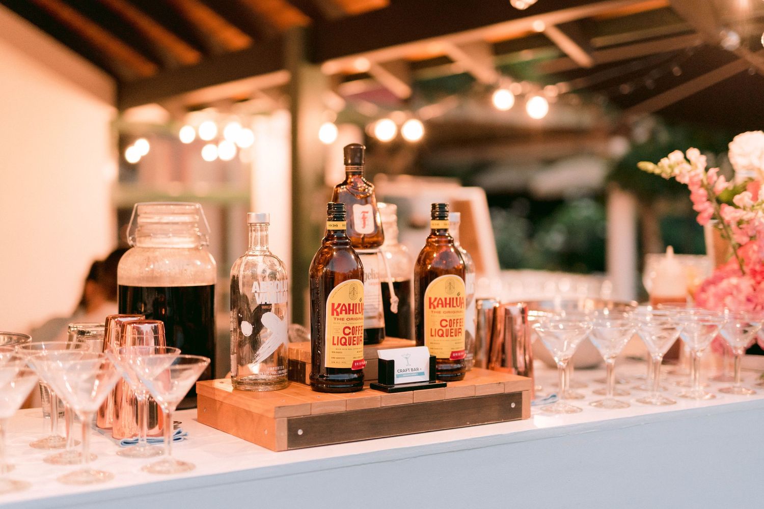 Elegant bar setup with liquor bottles and martini glasses on wooden display.