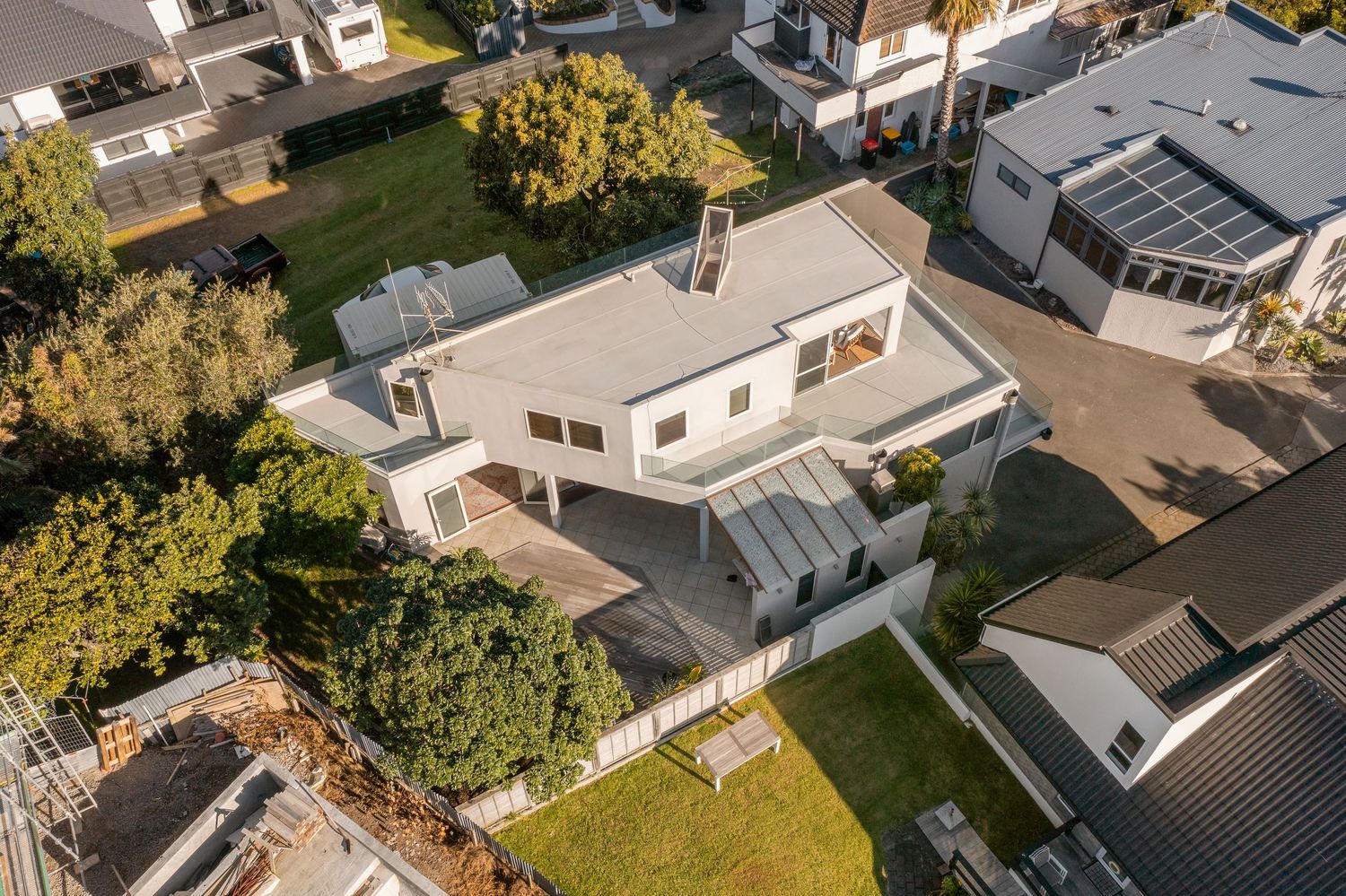 Drone shot of upscale suburban homes with solar panels and well-maintained properties.