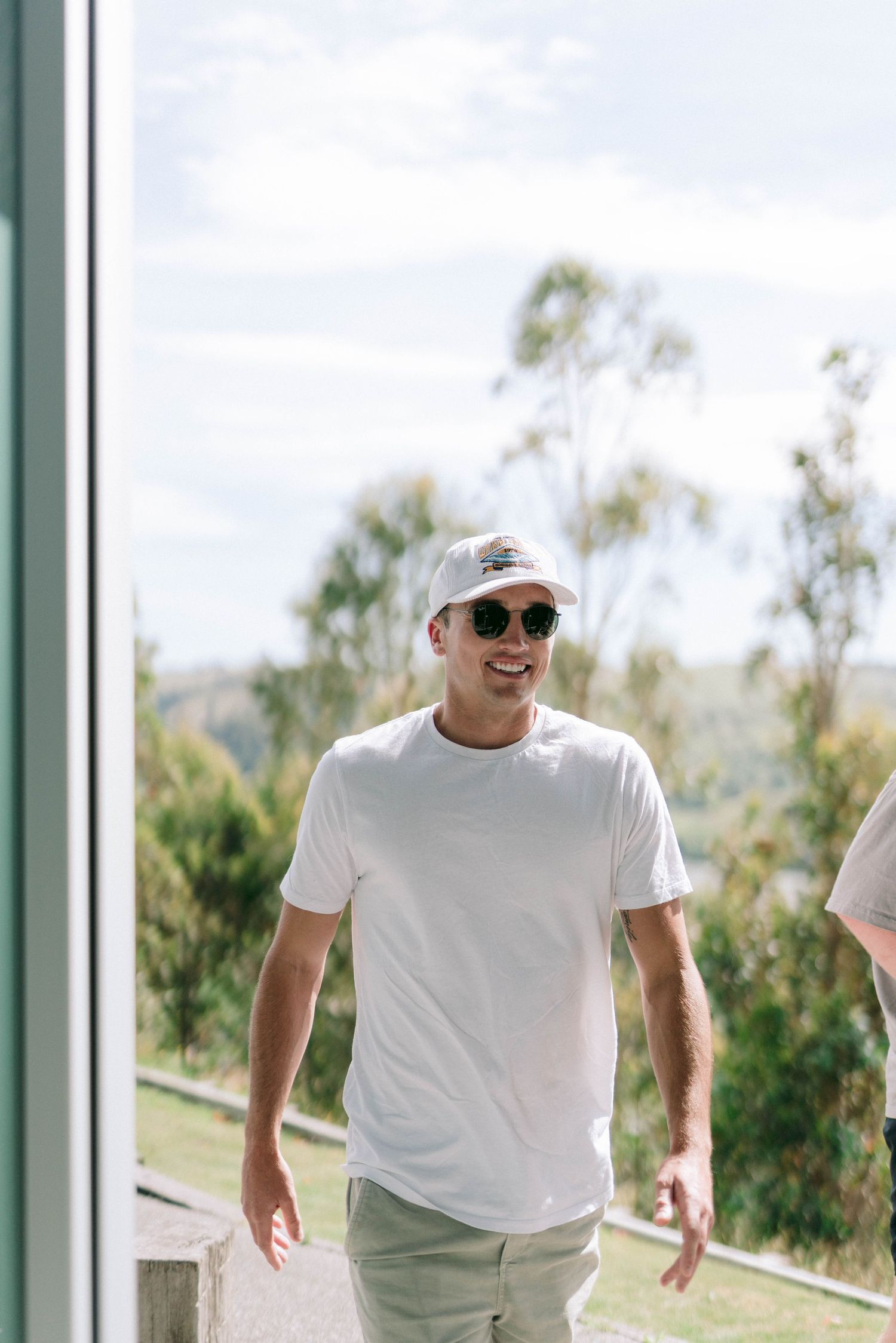 Groomsmen in casual white t-shirts walking together in a modern venue with glass walls.
