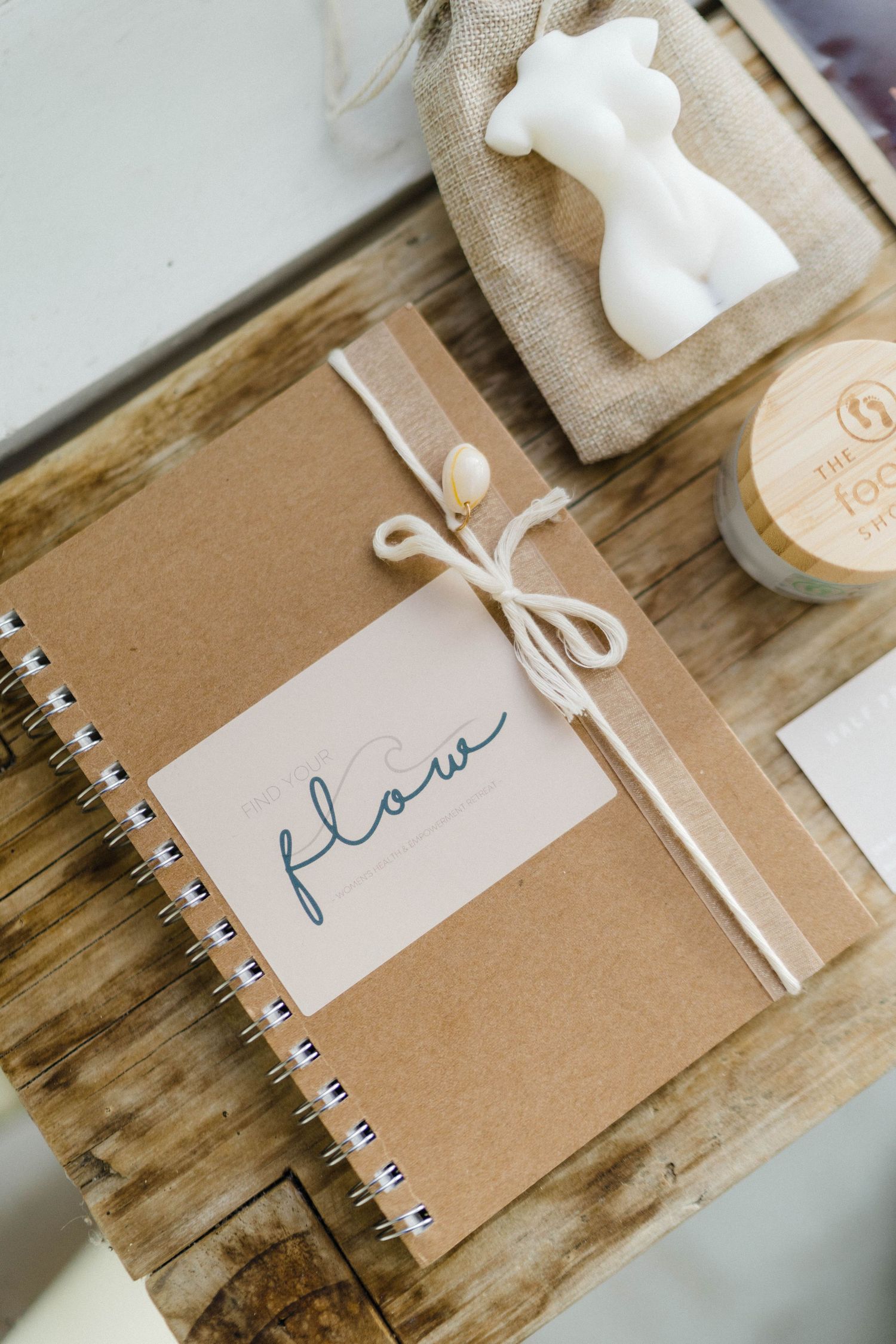 Minimalist journal labeled 'flow' with white decorative elements on wooden surface.