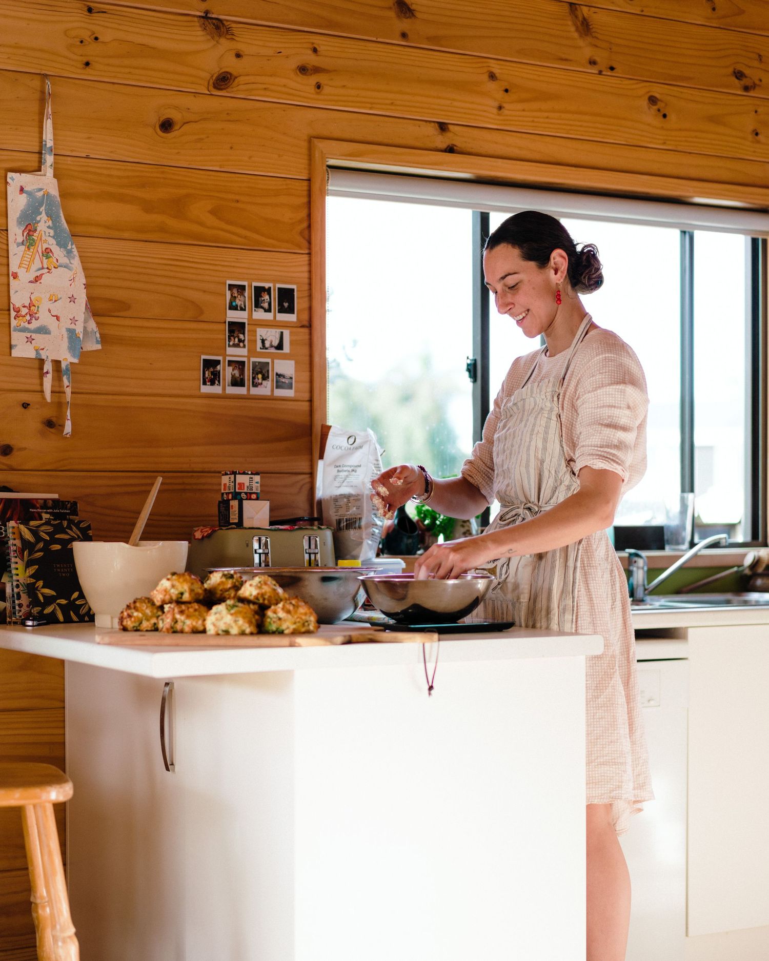 Sunlit rustic kitchen with wooden walls and white countertops showing baking setup.