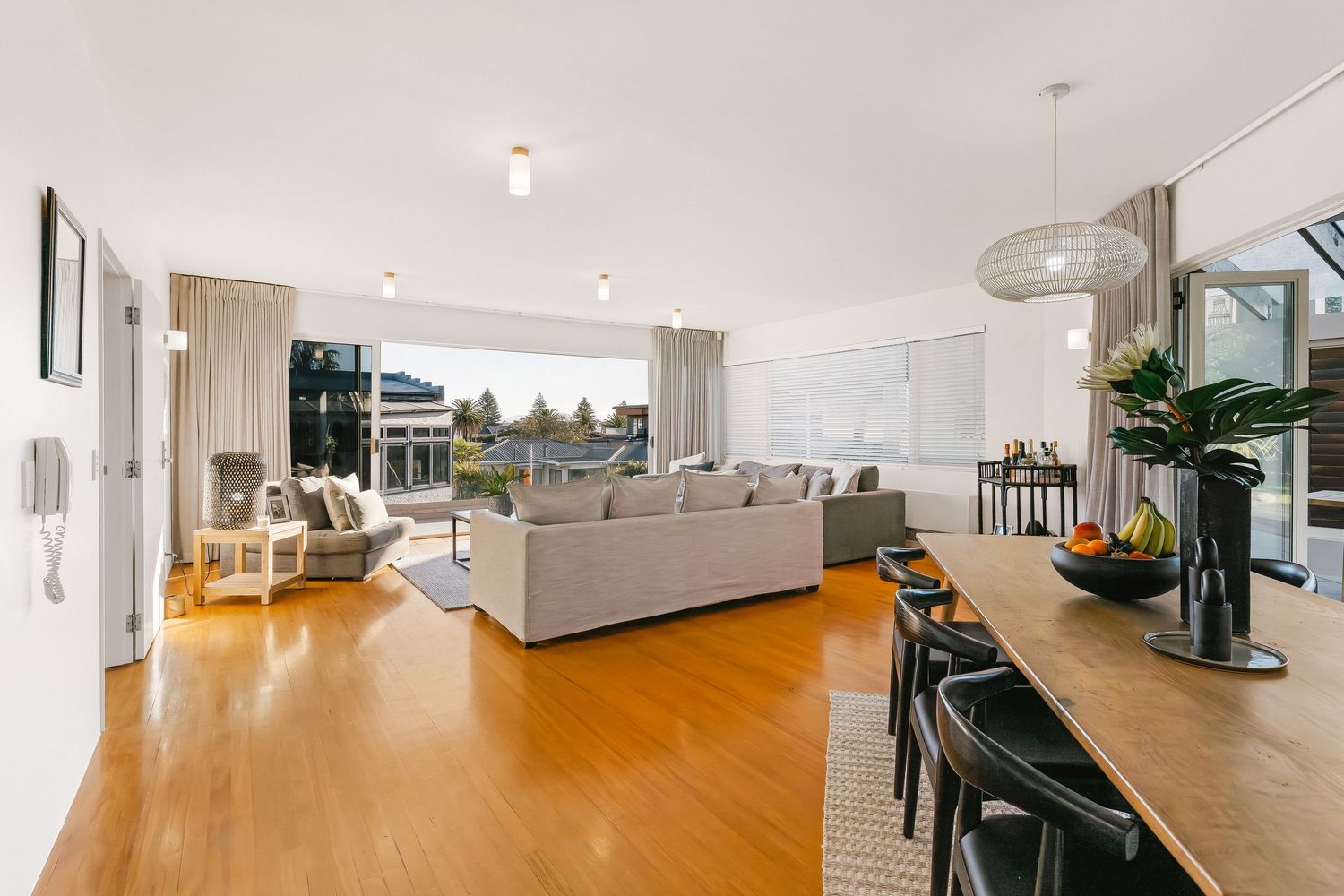 Open concept living area with hardwood floors and modern furnishings bathed in natural light.